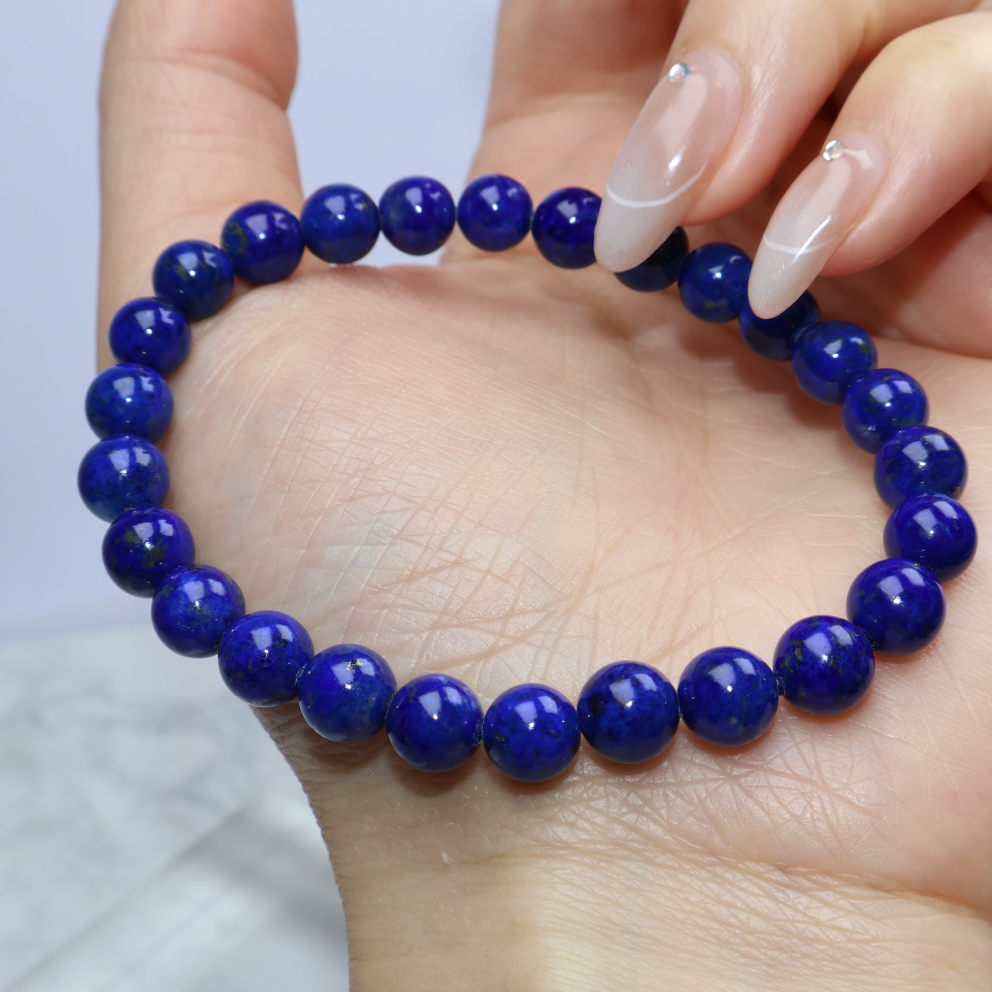 Close-up showing Lapis Lazuli beads in palm with soft light reflection
