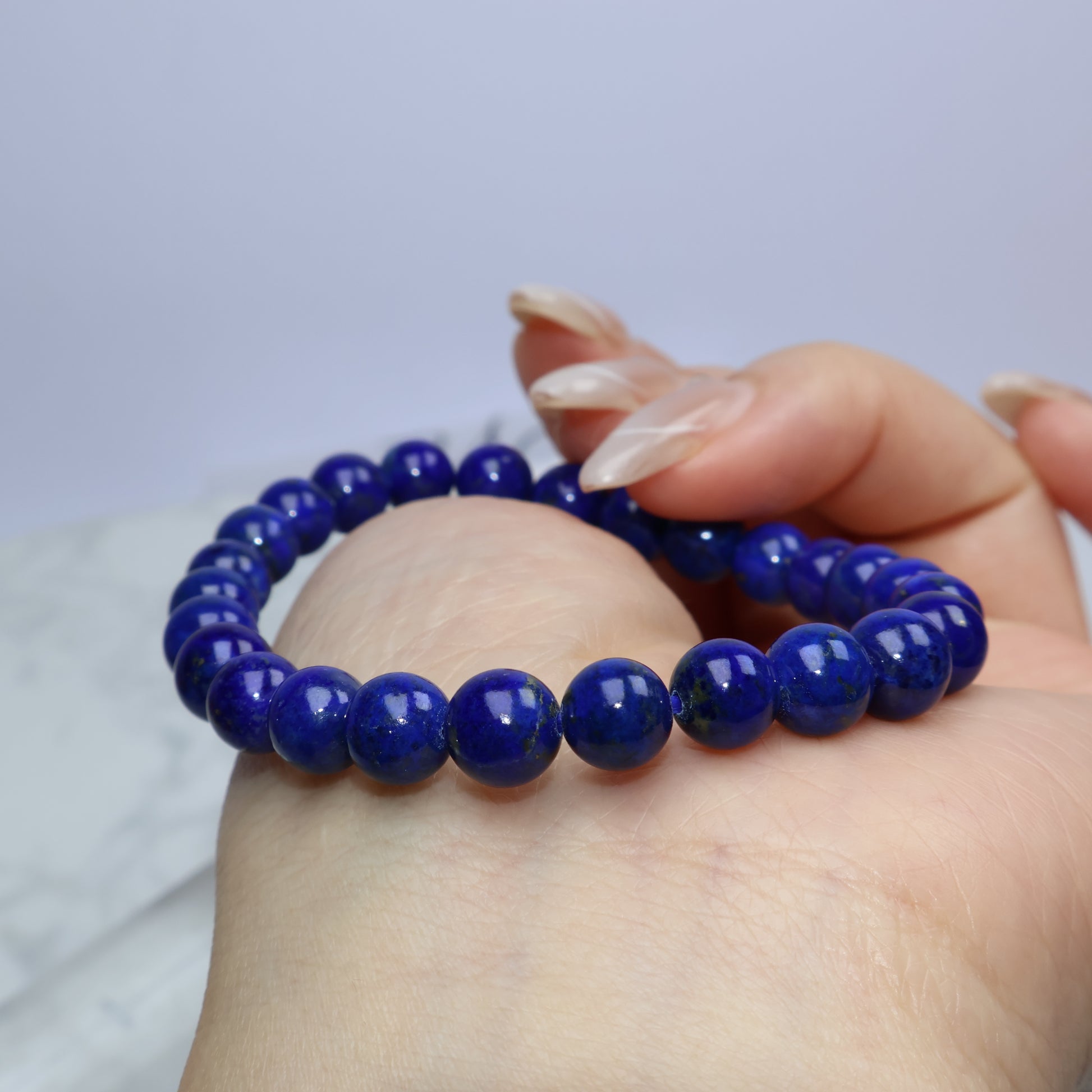 Low-angle shot of bracelet on hand with round polished beads