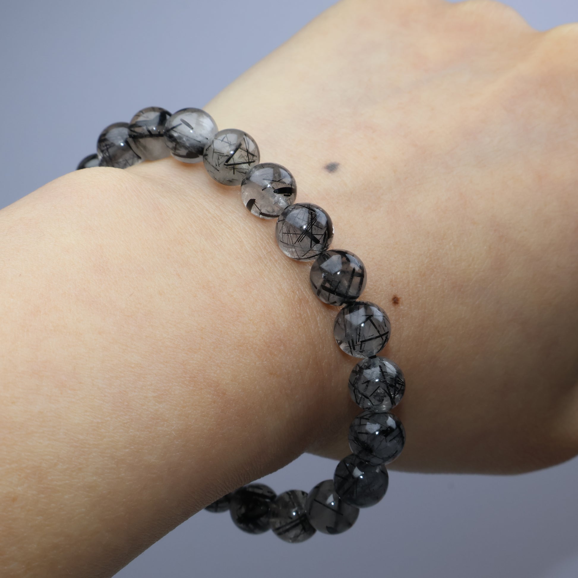 Worn on wrist – black rutiles within smoky quartz structure clearly displayed