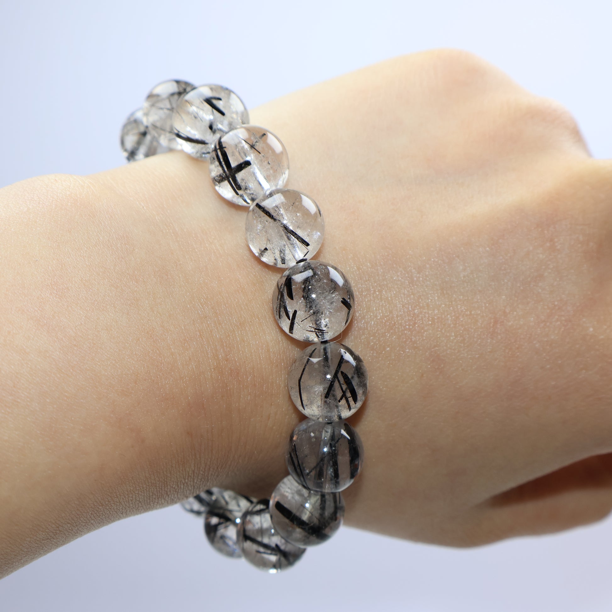 Wrist shot of the 11mm bracelet showing contrast between clear quartz and black rutile