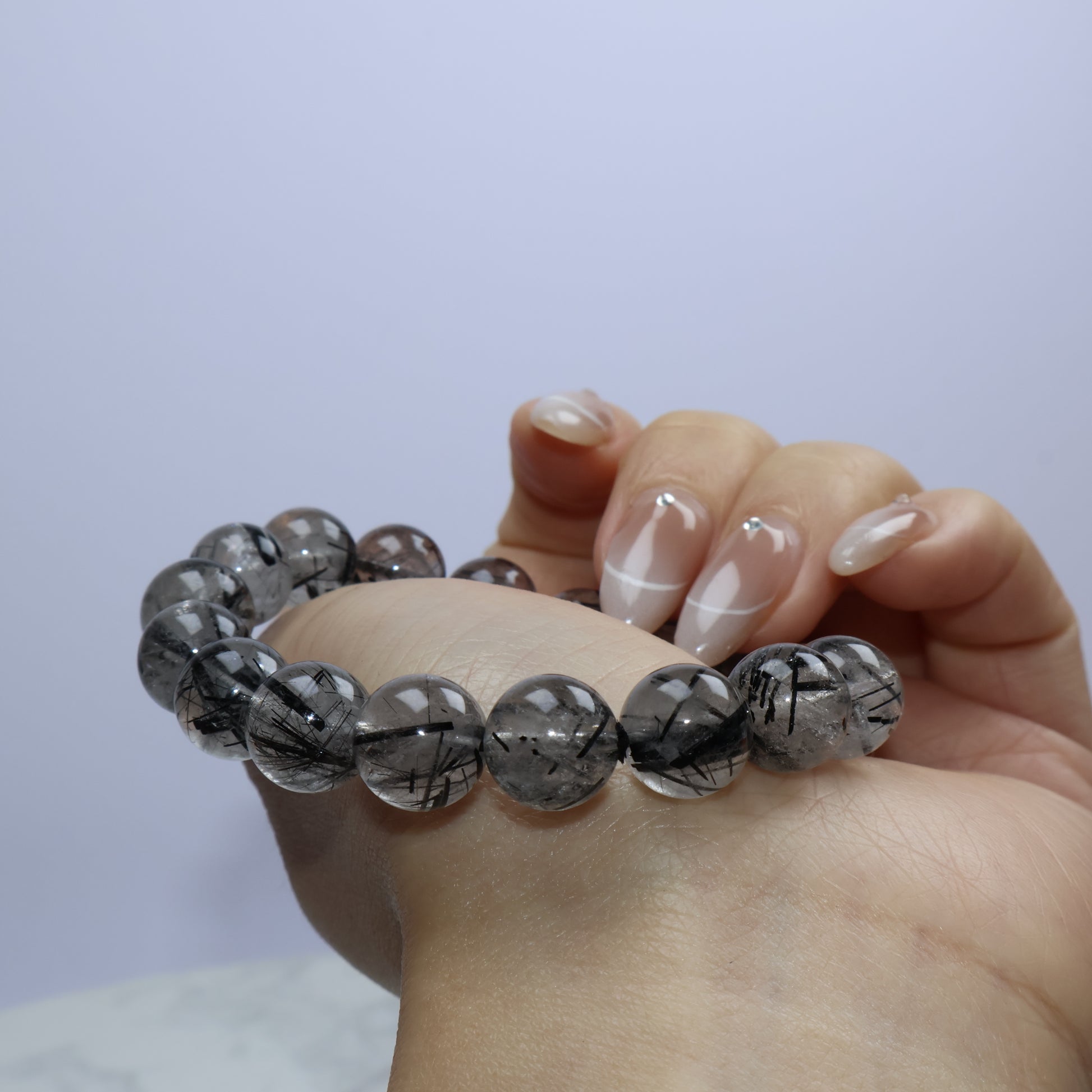 Close-up of black rutiles crossing inside semi-translucent beads