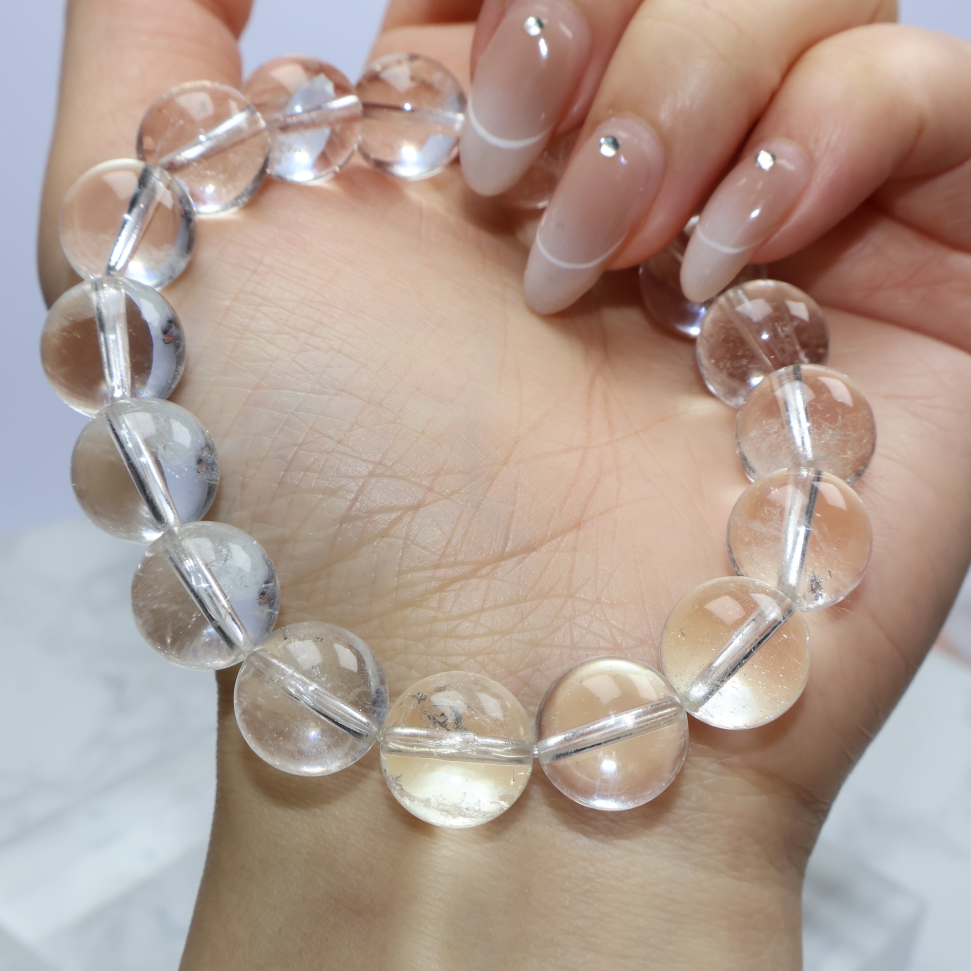 Bracelet curved across palm, showing gentle glow and natural inclusions