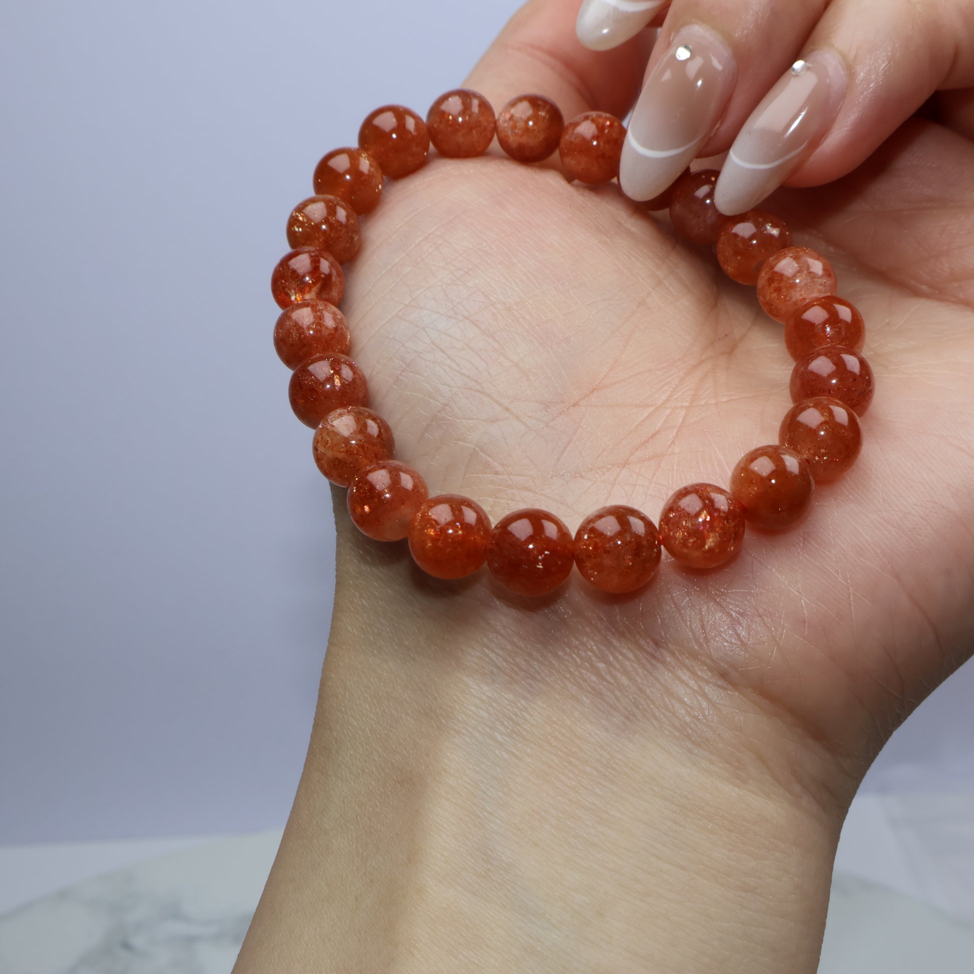Bracelet gently held across hand, showing lustrous surface