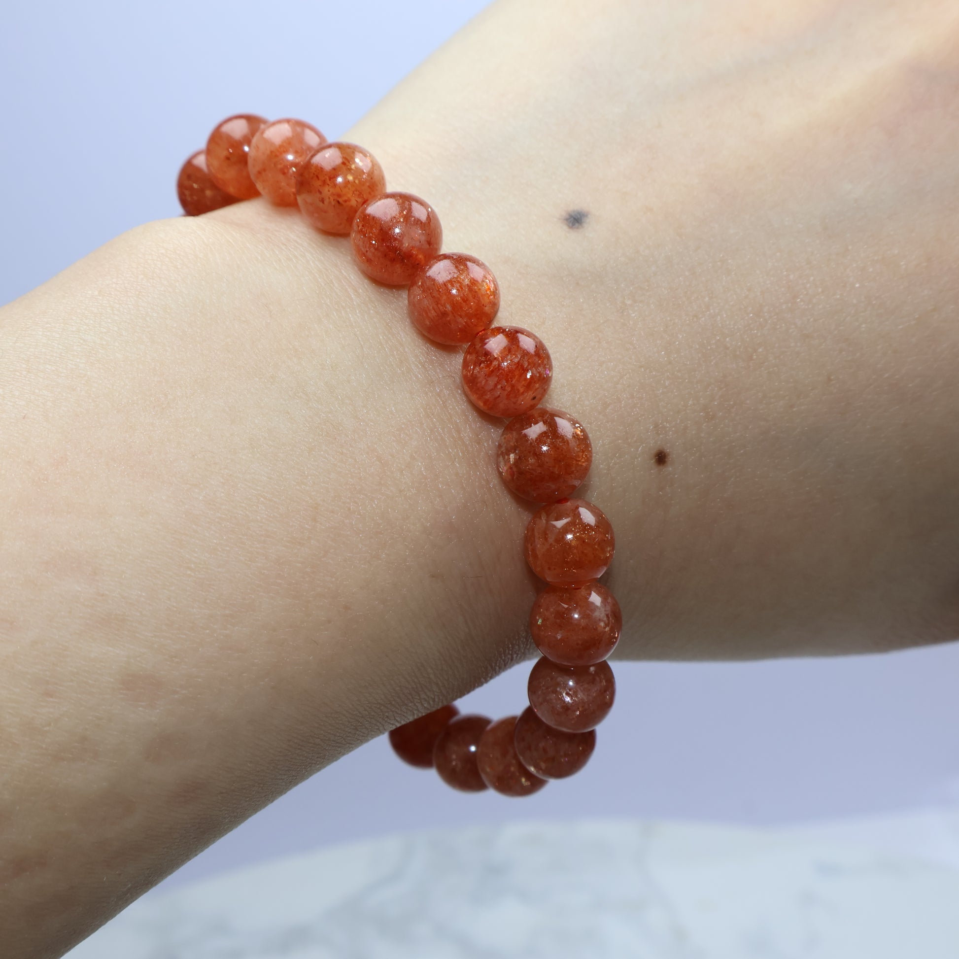 Bracelet on wrist with side view showing even round beads