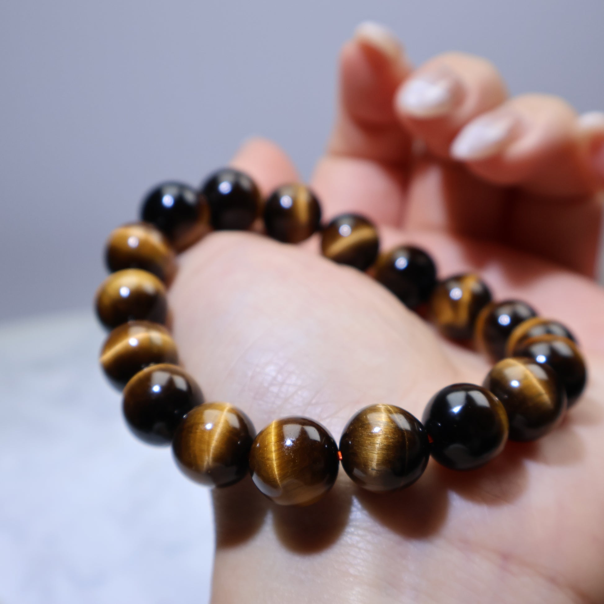 Close-up of bracelet resting on palm, highlighting silky luster and natural banding
