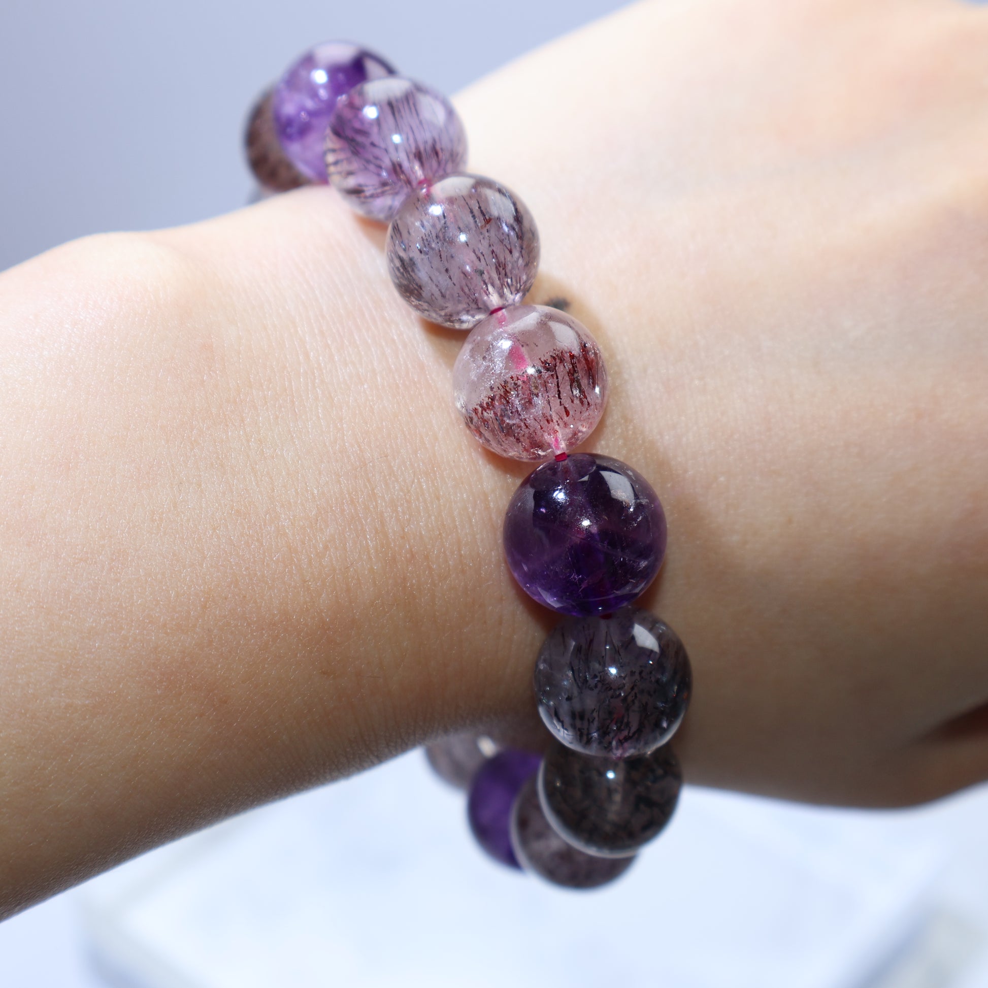 Wrist shot showing 16cm fit and glossy 12.8–13.5mm beads