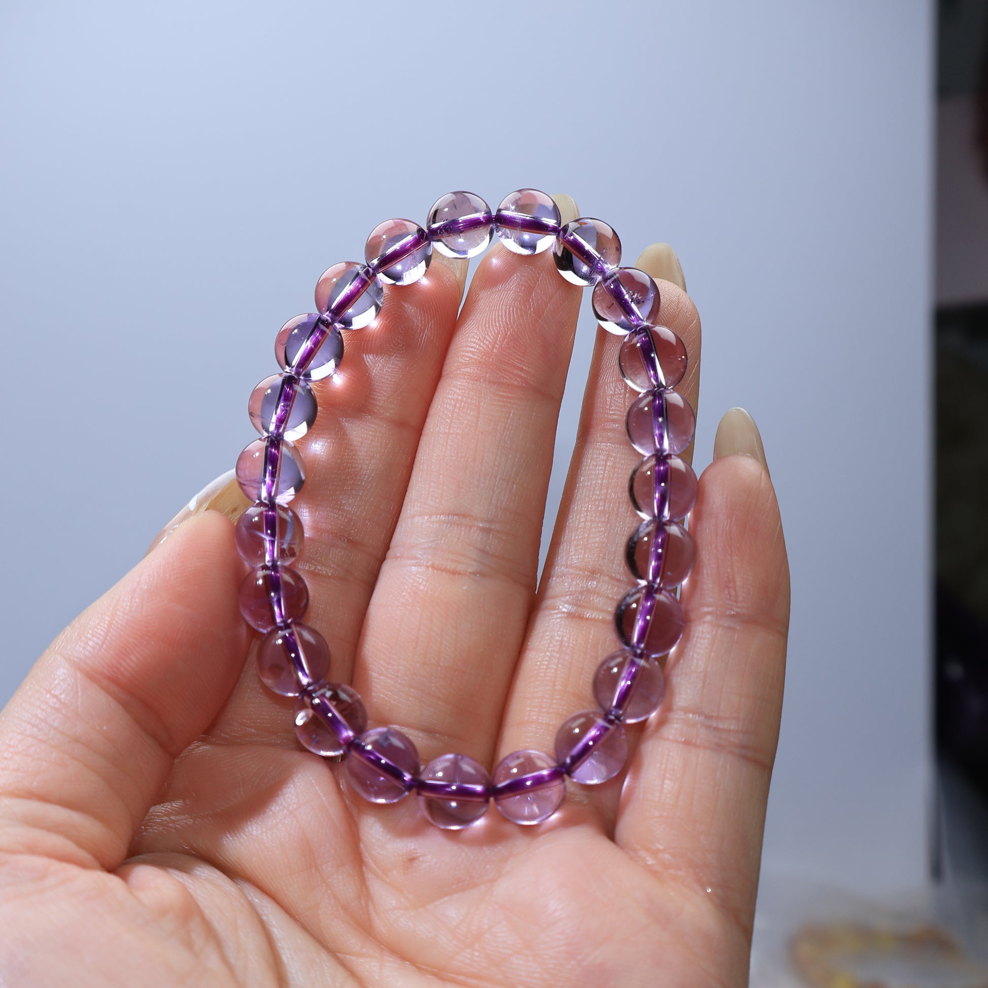 Handheld shot of Amethyst bracelet, showing clarity and smooth polish
