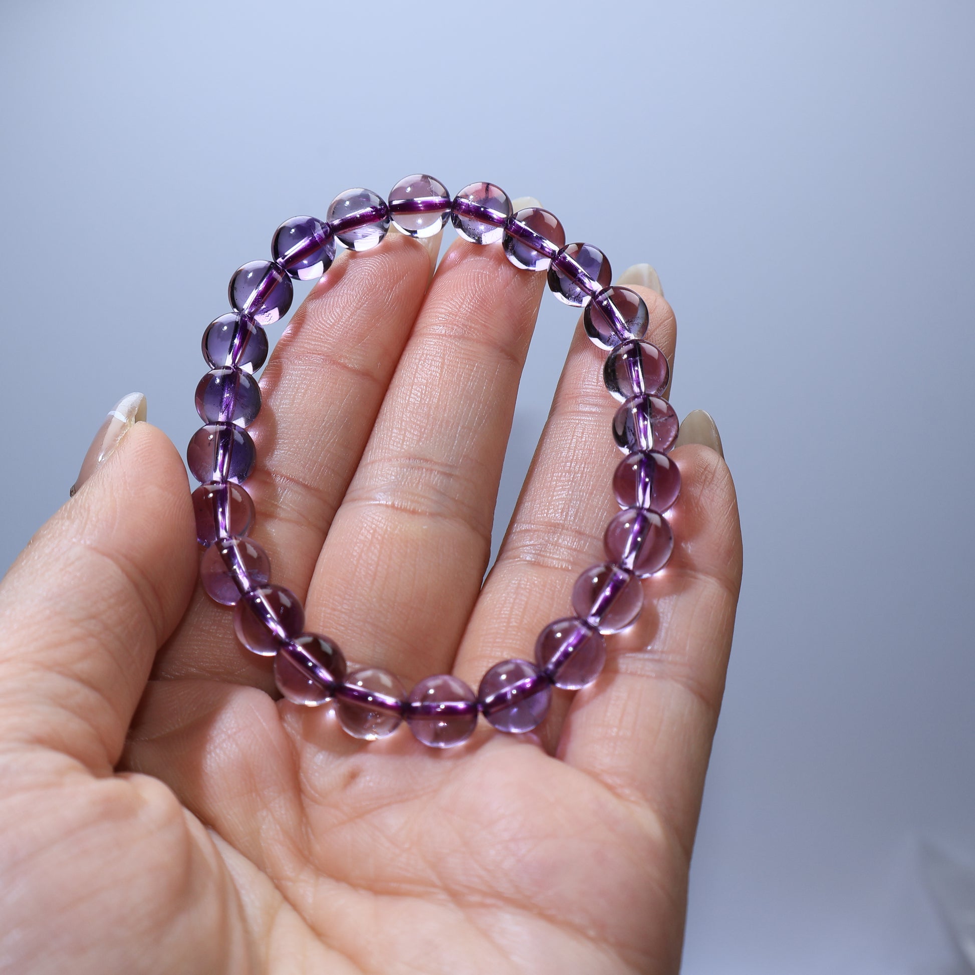 Handheld view of Amethyst bracelet, highlighting clarity and even bead size