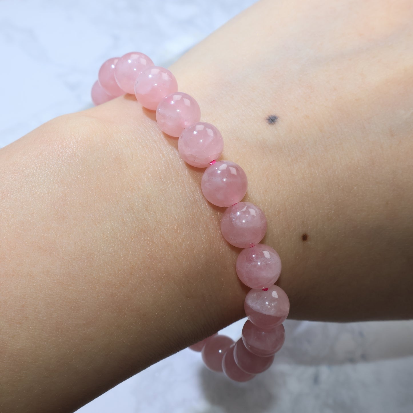 Side wrist view of Madagascar Rose Quartz bracelet, showing snug fit for 15.5cm wrist size.