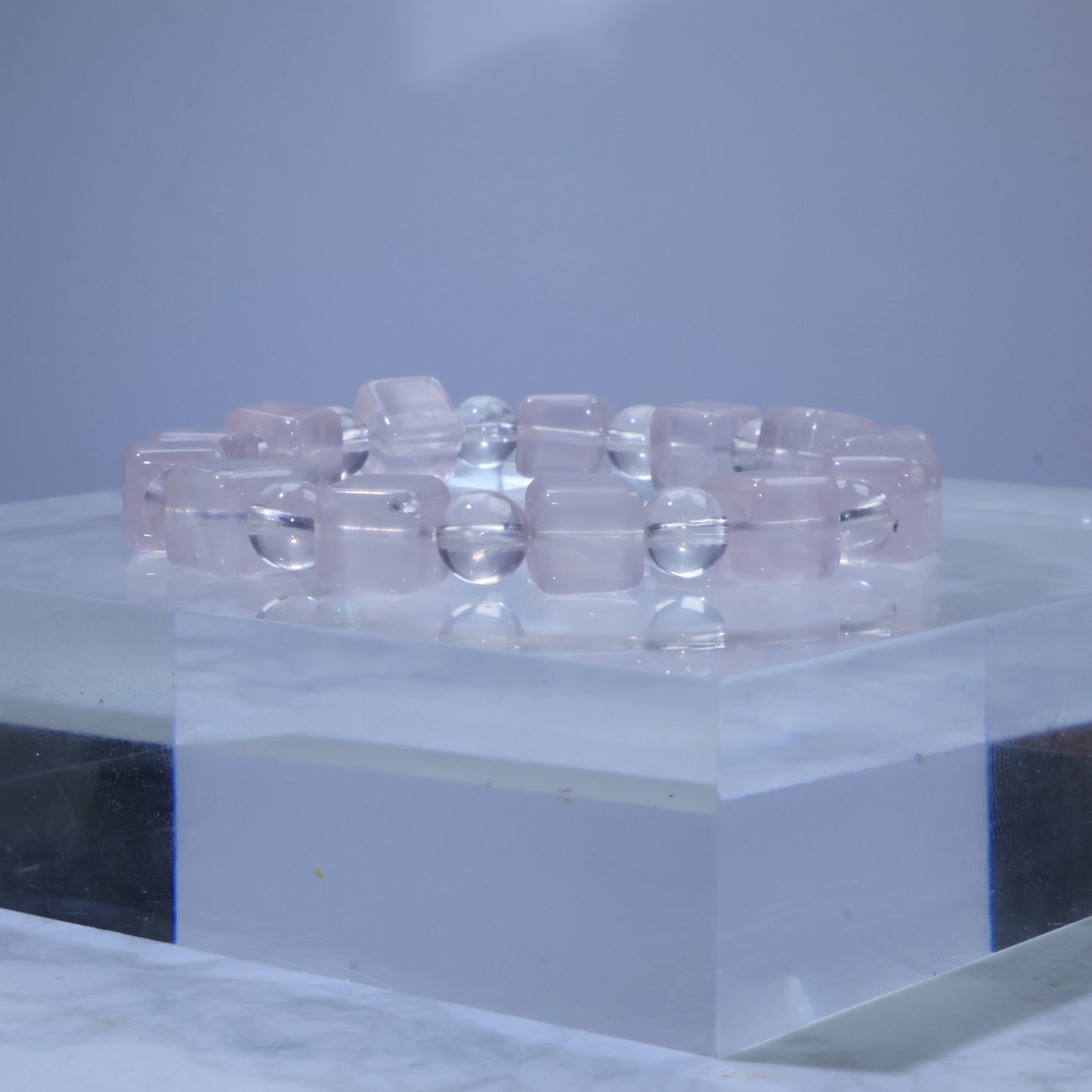 Side-angle view of Rose Quartz bracelet showing alternating square-cut and round beads with soft pink tone.