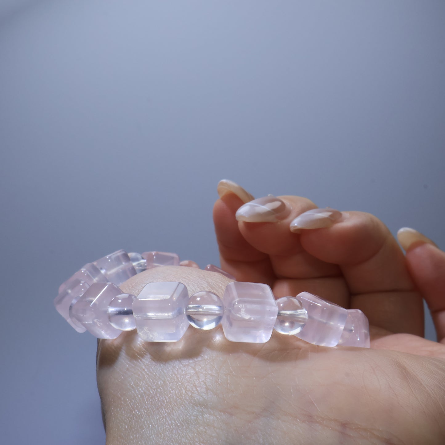 Close-up of Rose Quartz bracelet on wrist, focusing on the interplay between square and round beads.