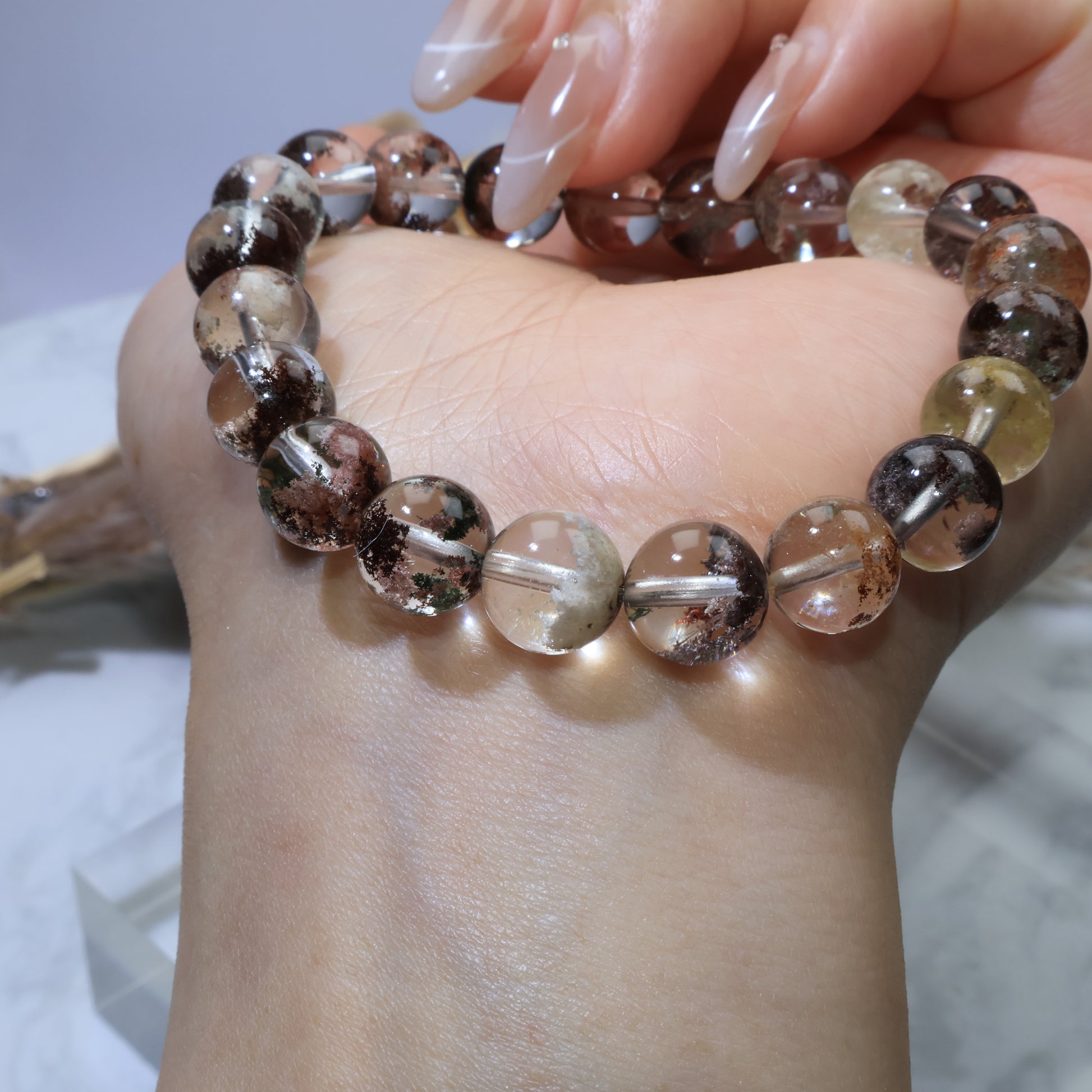 Wrist shot of Scenic Phantom Quartz bracelet with visible red, green, and white phantom inclusions