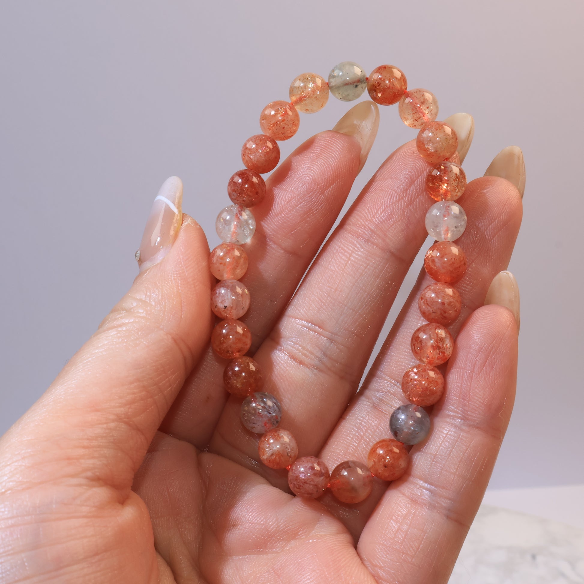 Hand holding Arusha Sunstone bracelet showing sparkling inclusions