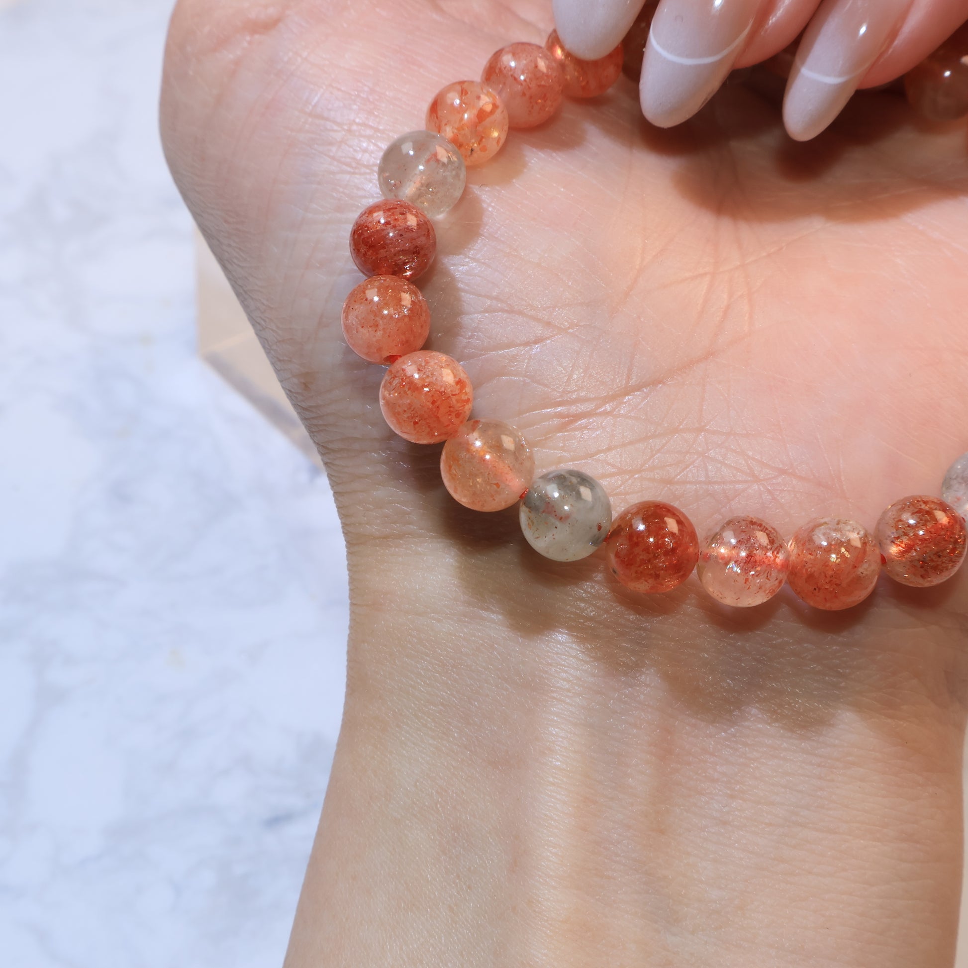 Close-up of bracelet section with mix of reddish-orange and grey-green beads