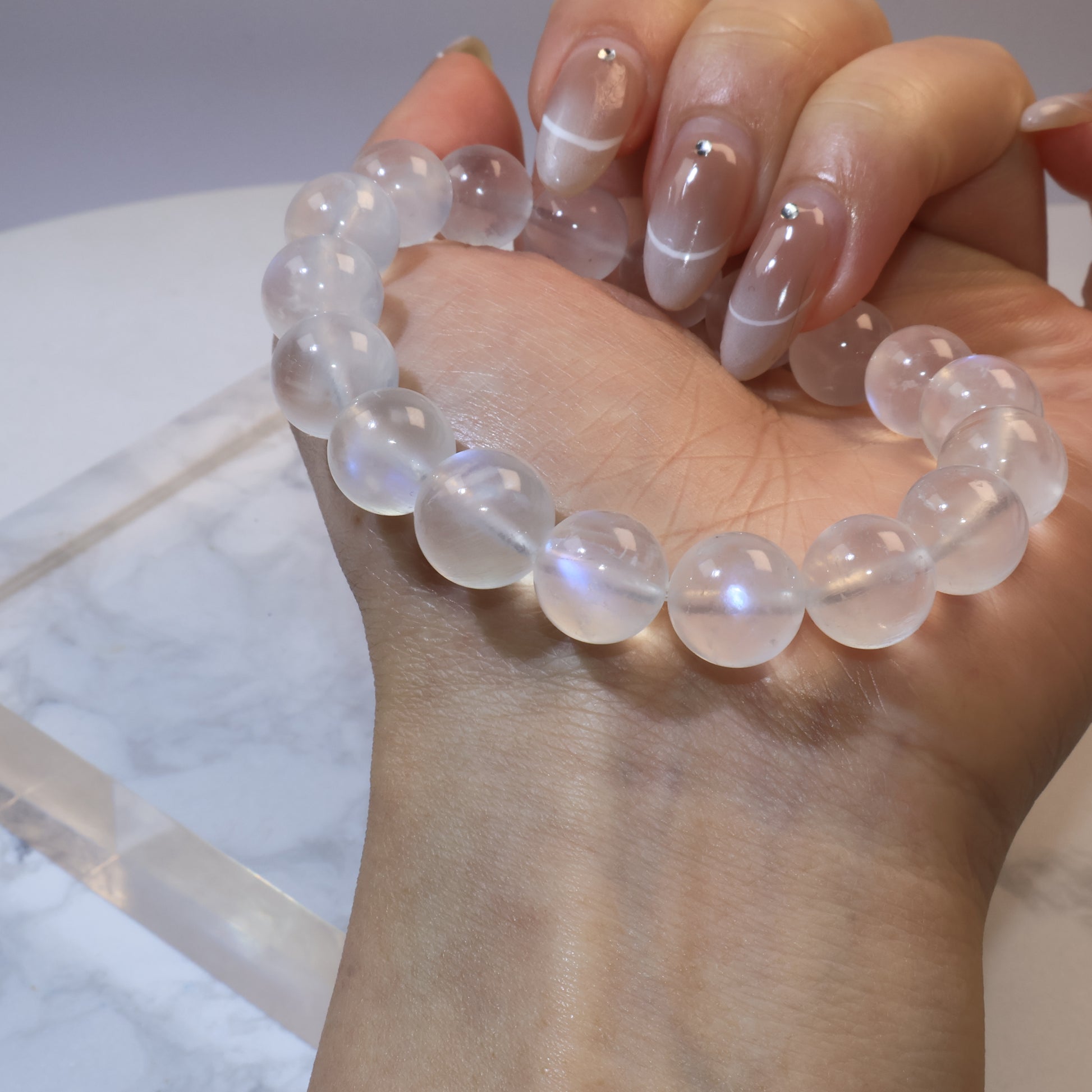 Moonstone bracelet wrapped on hand, highlighting smooth round beads and sheen