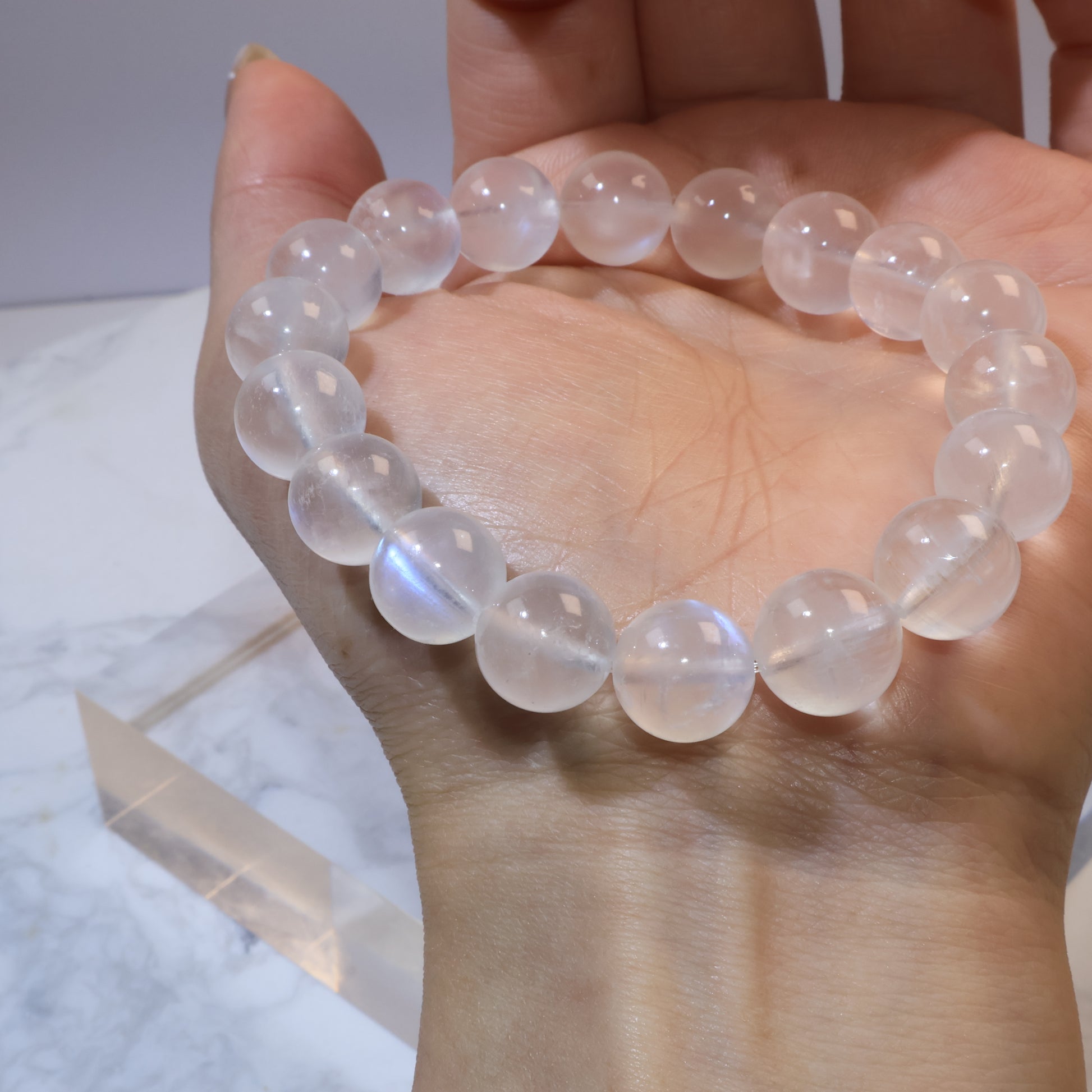Close-up of moonstone beads in hand, showing clarity and internal texture