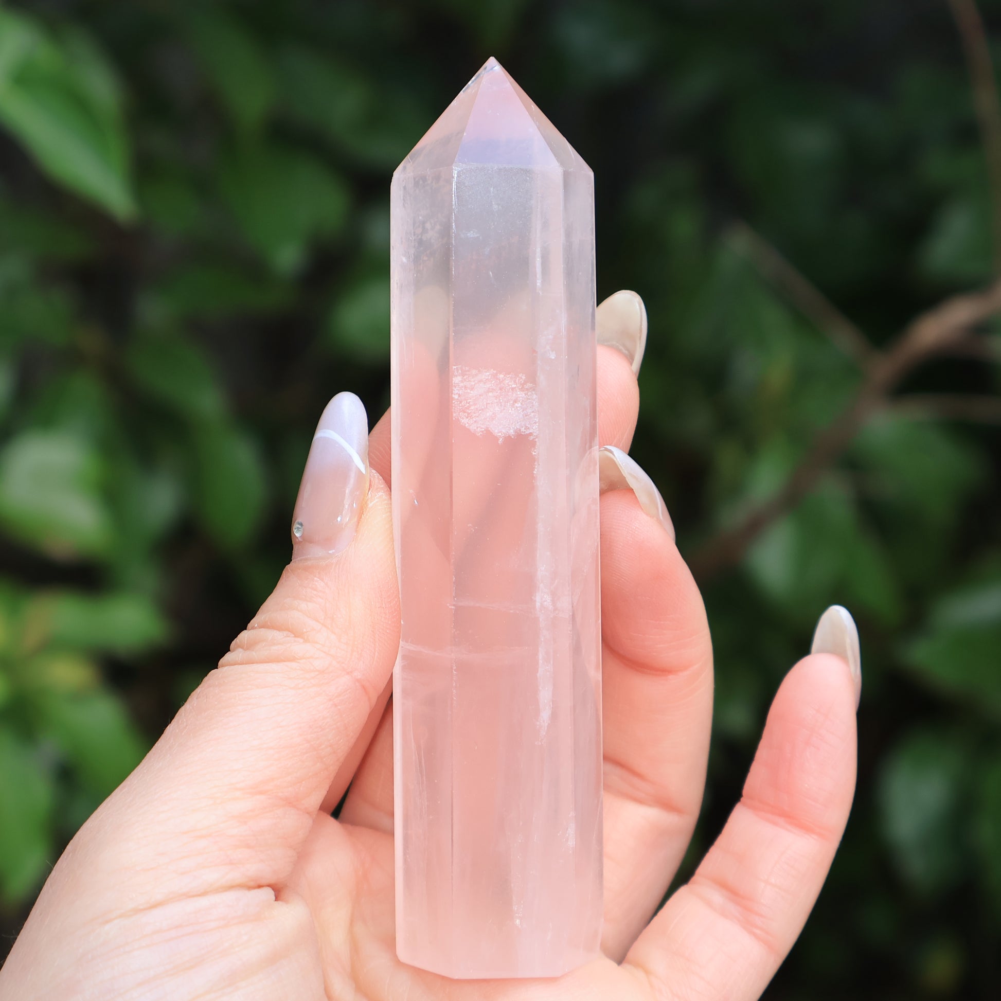 Close-up of a rose quartz tower with visible cloudy texture in the center, symbolizing love and healing.