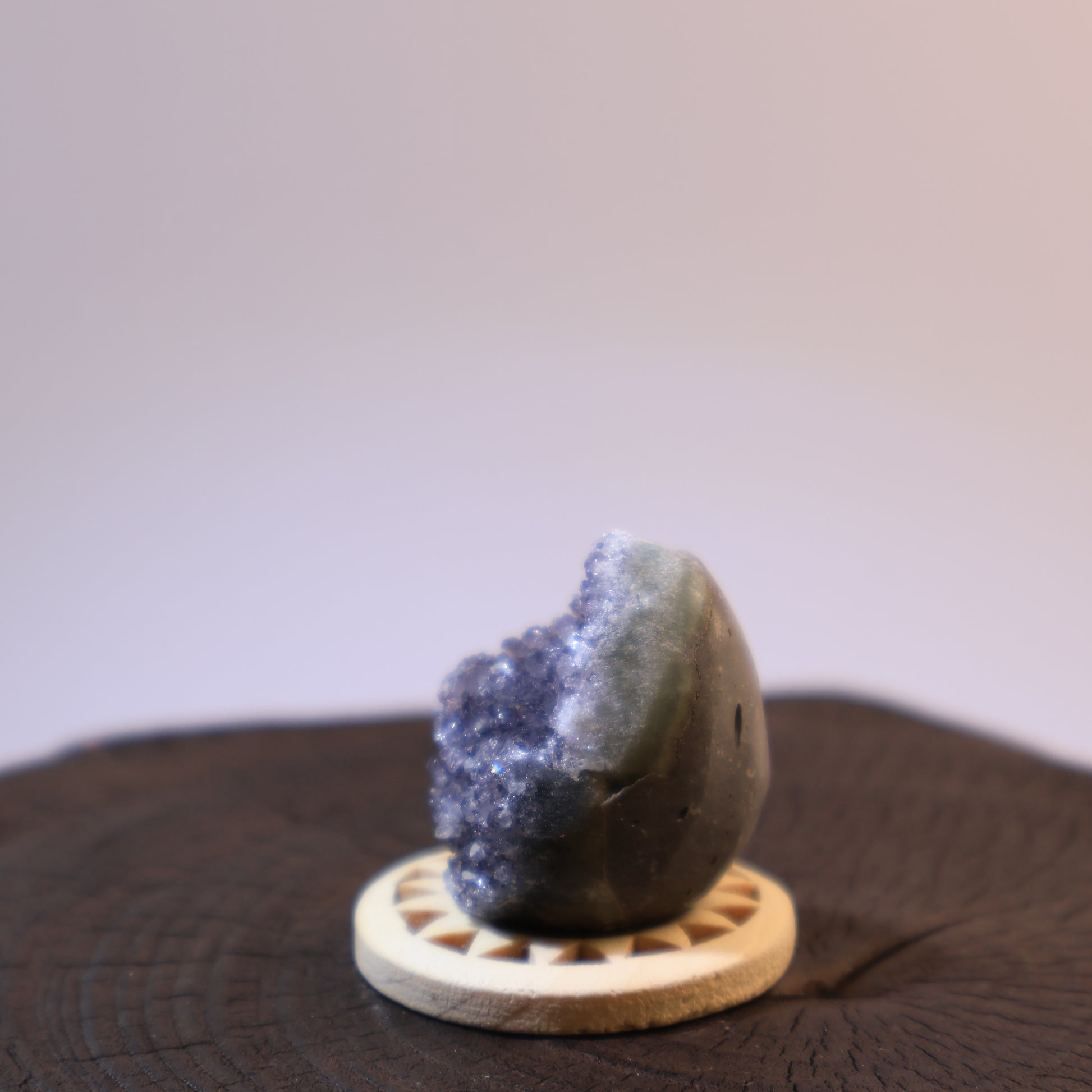 Another side angle of grey quartz geode egg with crystal exposure.