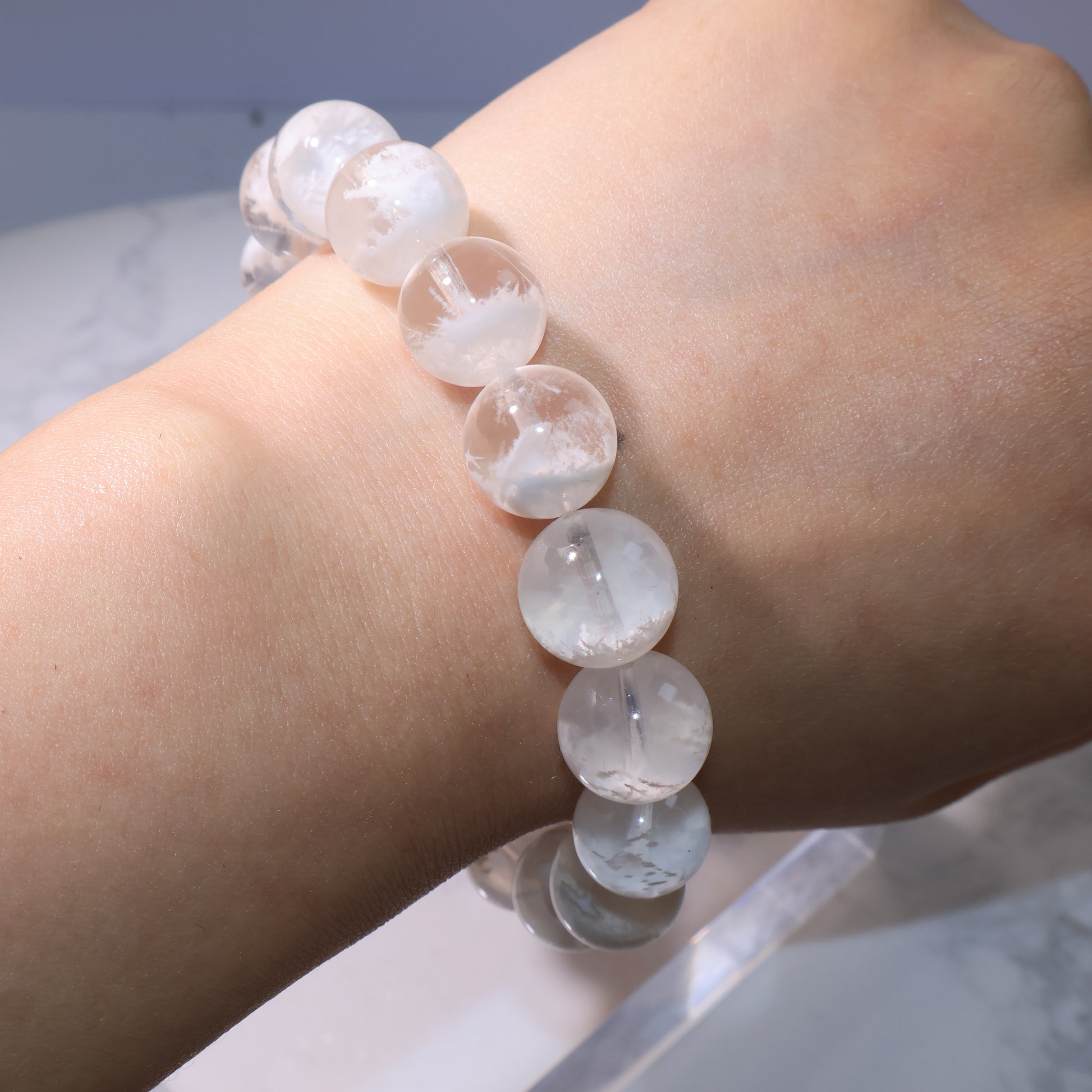 Bracelet worn on wrist, highlighting white phantom inclusions inside beads.