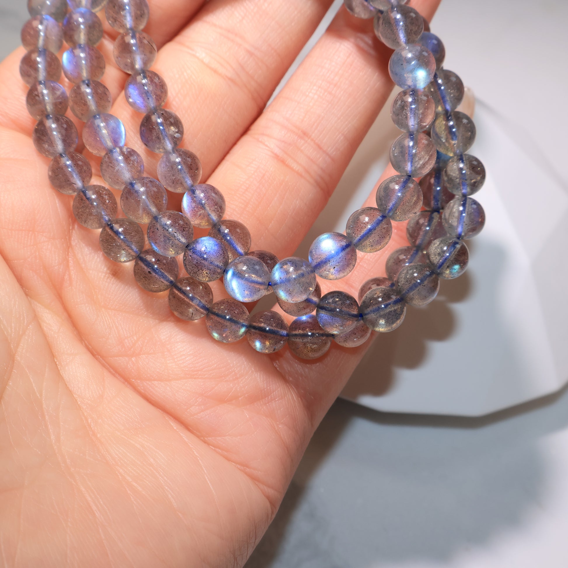 Bracelet strands in hand with luminous sheen|手中拉長石手串,散發神秘光澤