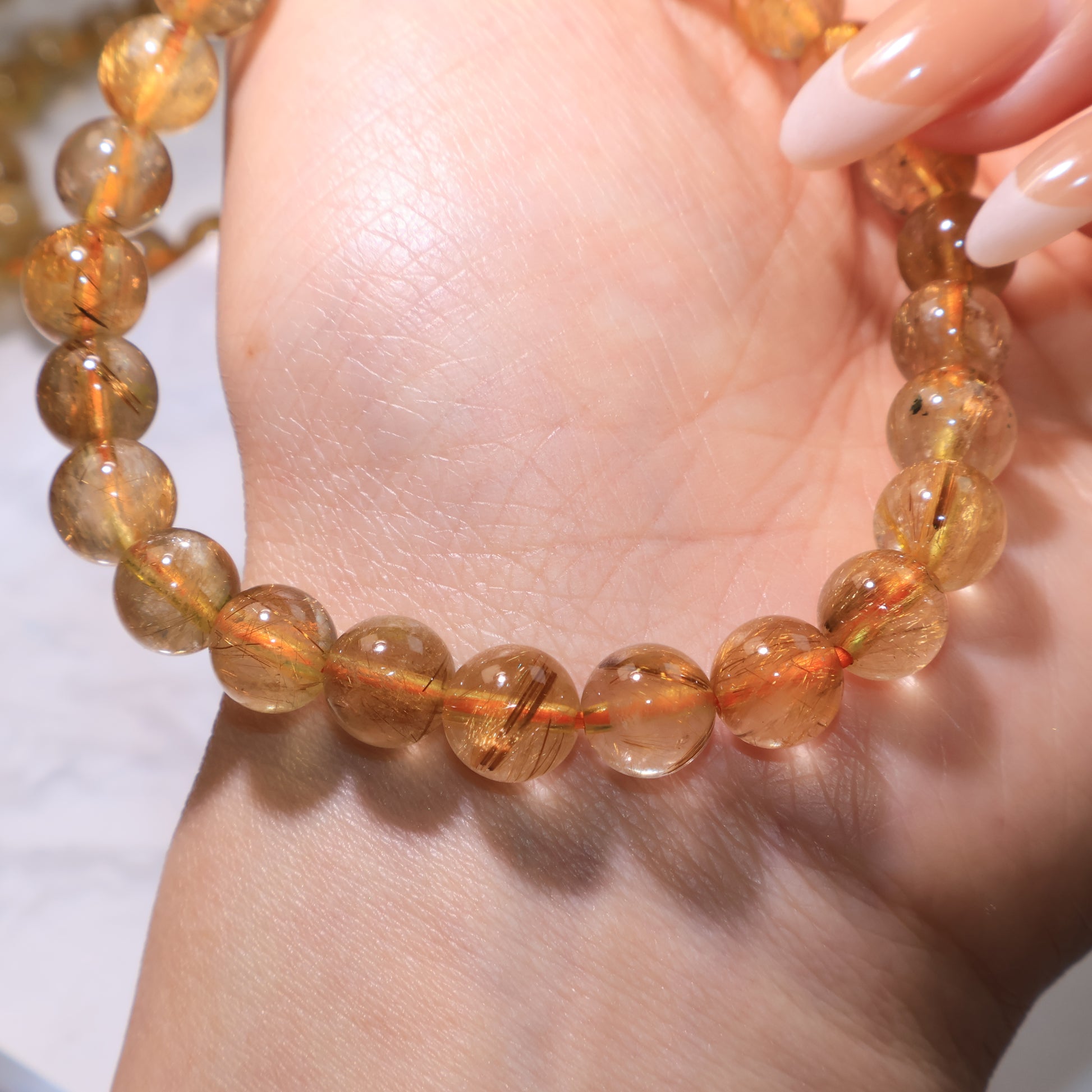 Macro shot of Rutilated Quartz bracelet, showing natural rutile inclusions and clarity.