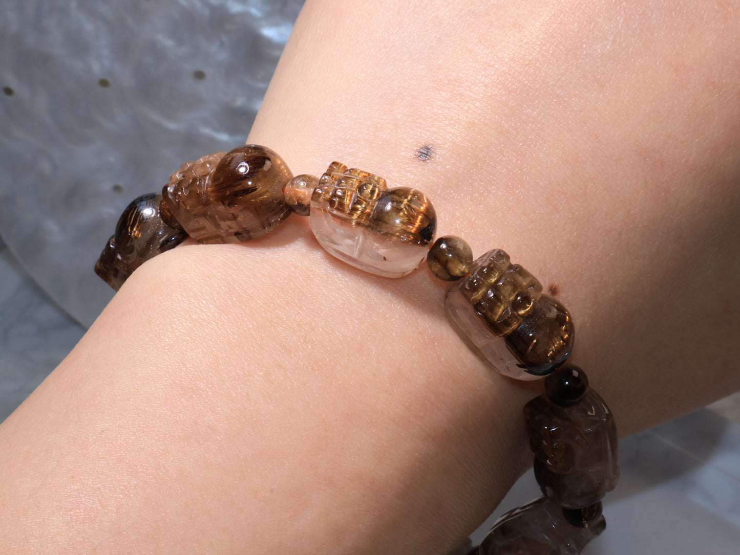 Close-up wrist view under soft light, showing clarity and rutilated reflections.