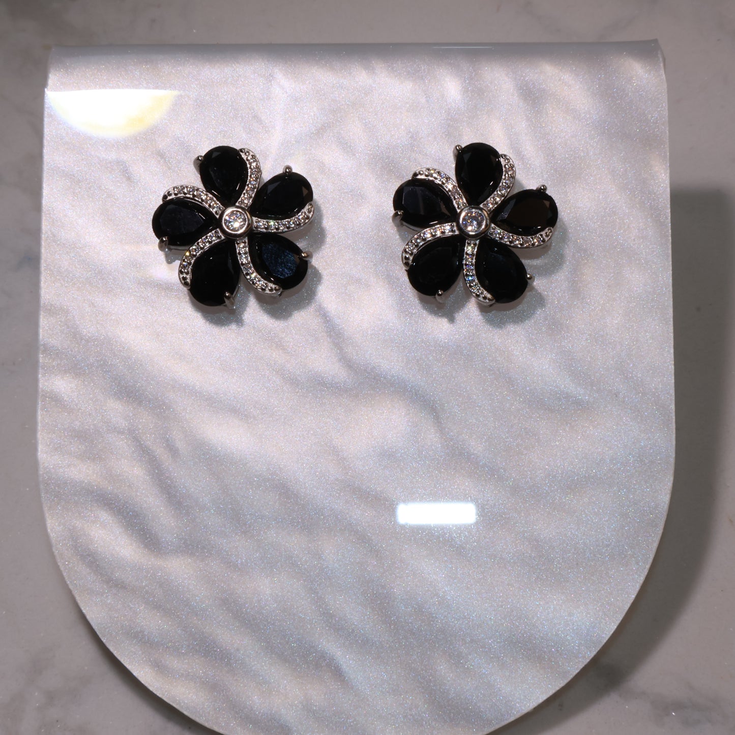 Overhead view showing the symmetrical floral design and sparkle of the zircon center.