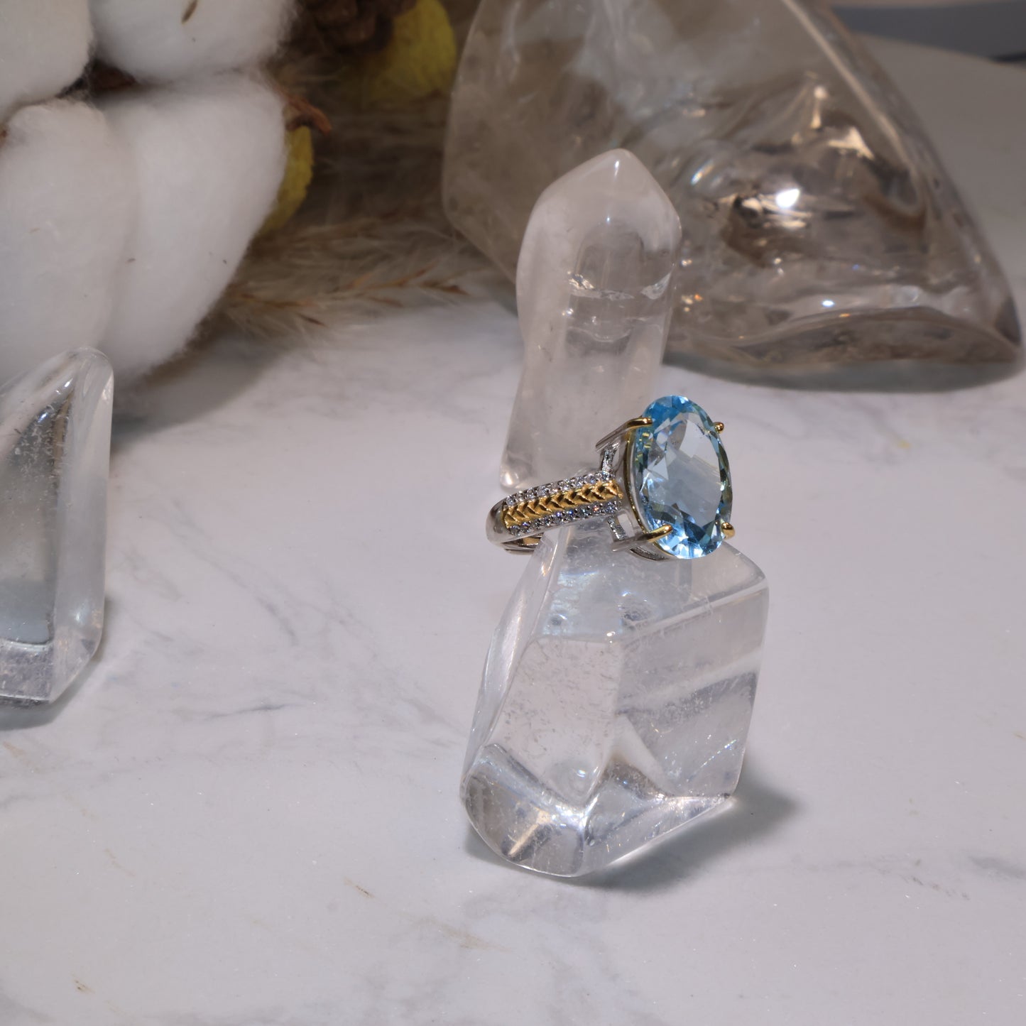 Side view showing the oval-cut blue topaz set on an S925 sterling silver and gold-plated band, highlighting the gemstone’s clarity.