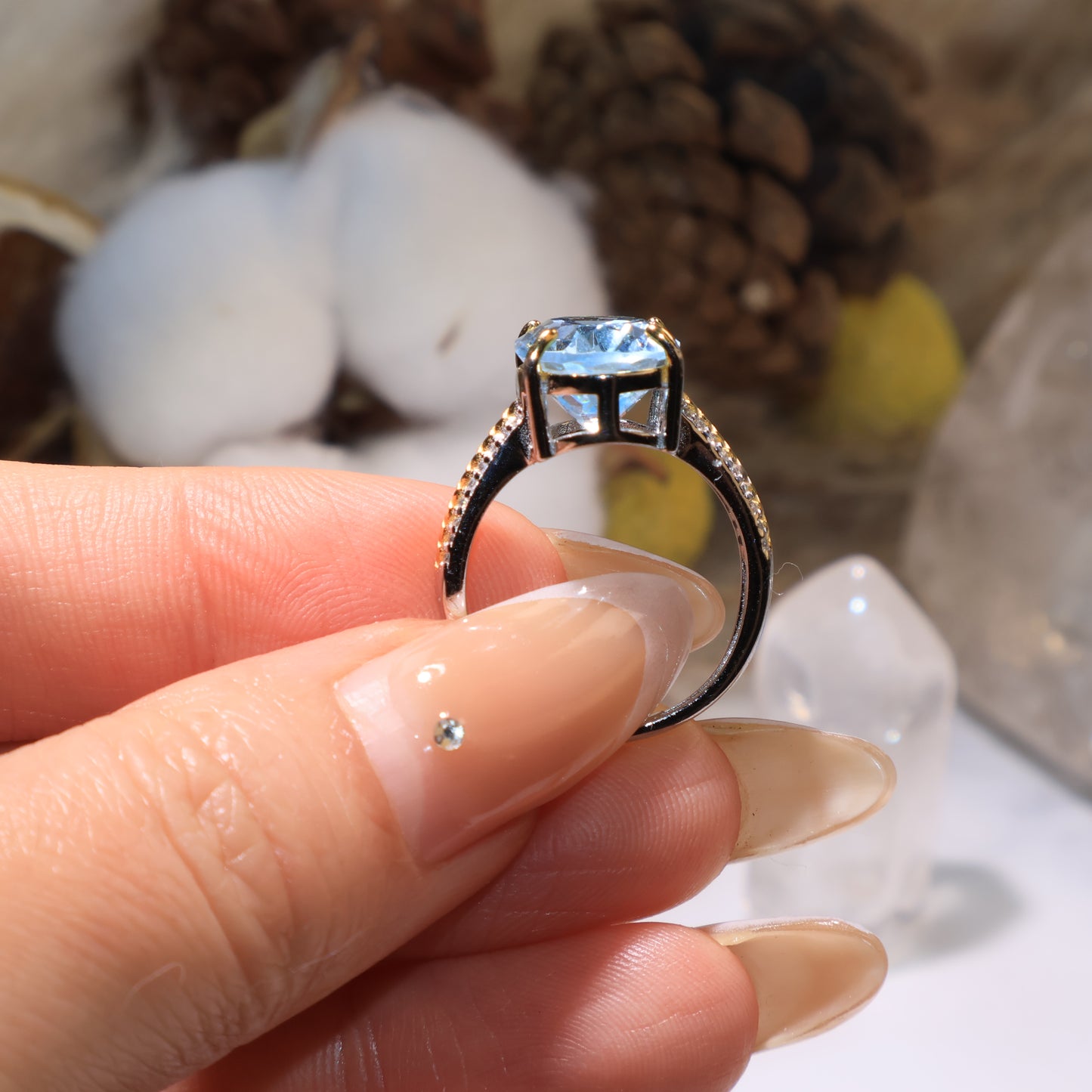 Close-up of the ring held by hand, focusing on the prong setting and fine silver craftsmanship.