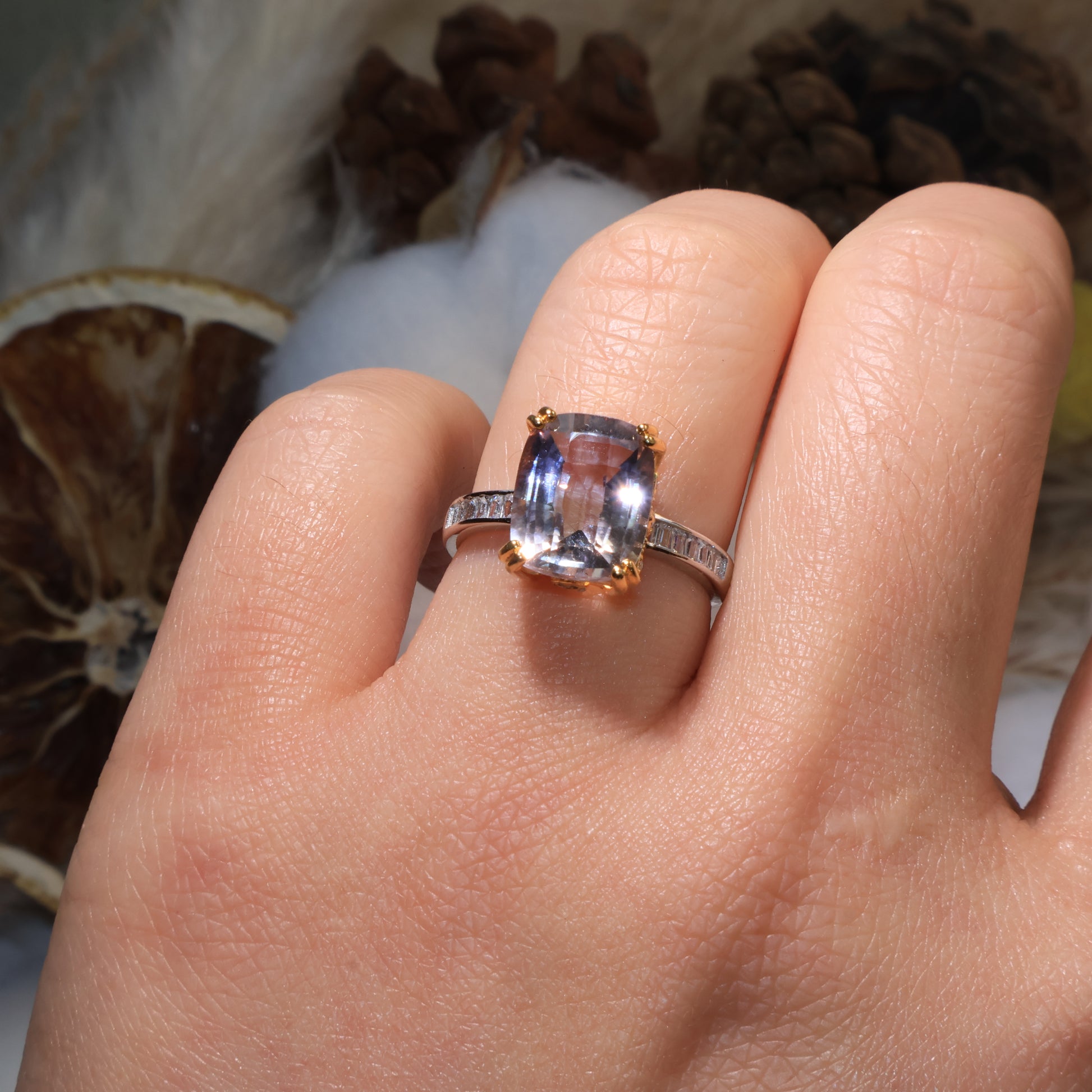 Ametrine ring worn on hand, glowing with gentle purple and golden tones under light.