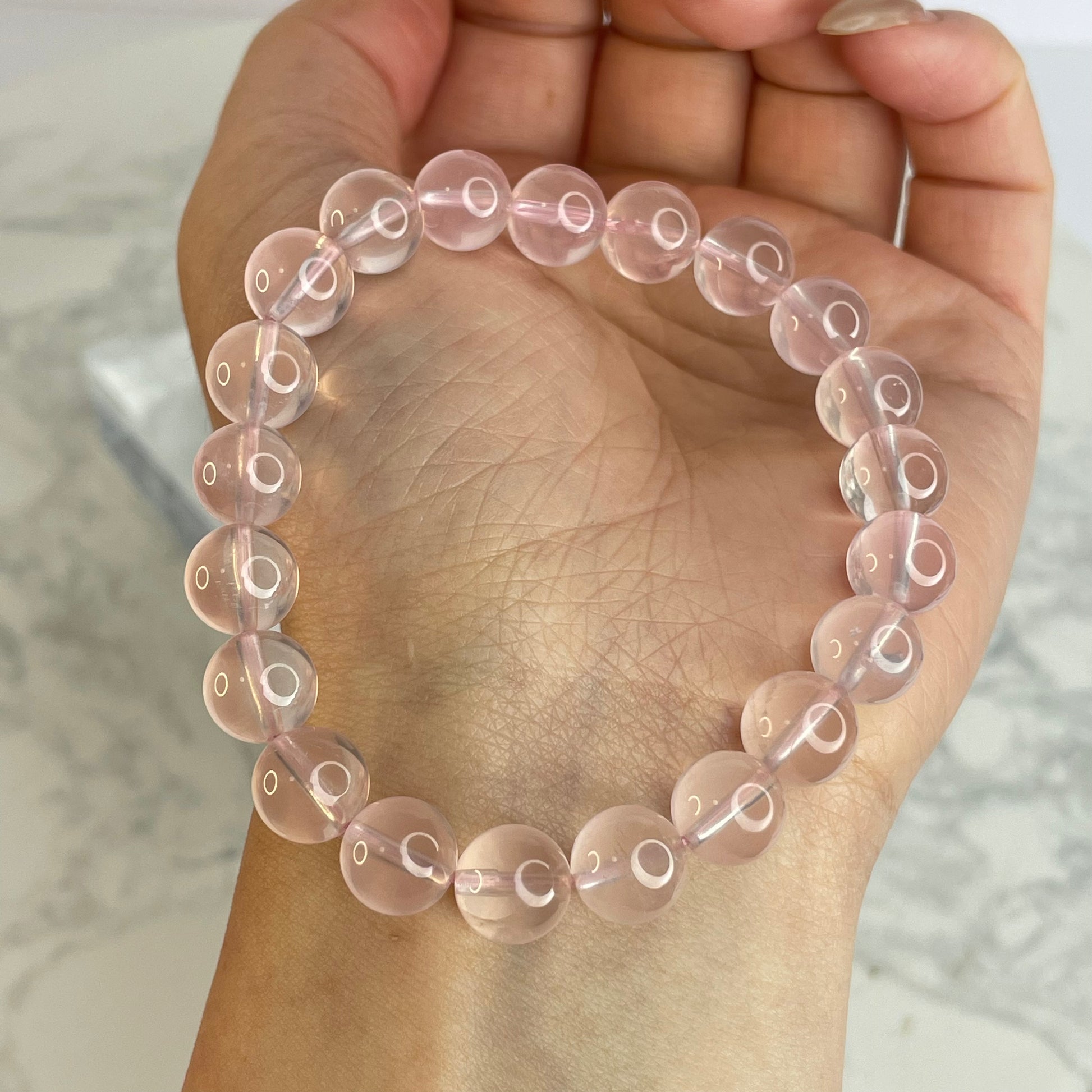 Rose Quartz bracelet 8mm beads worn on wrist, highlighting natural translucence