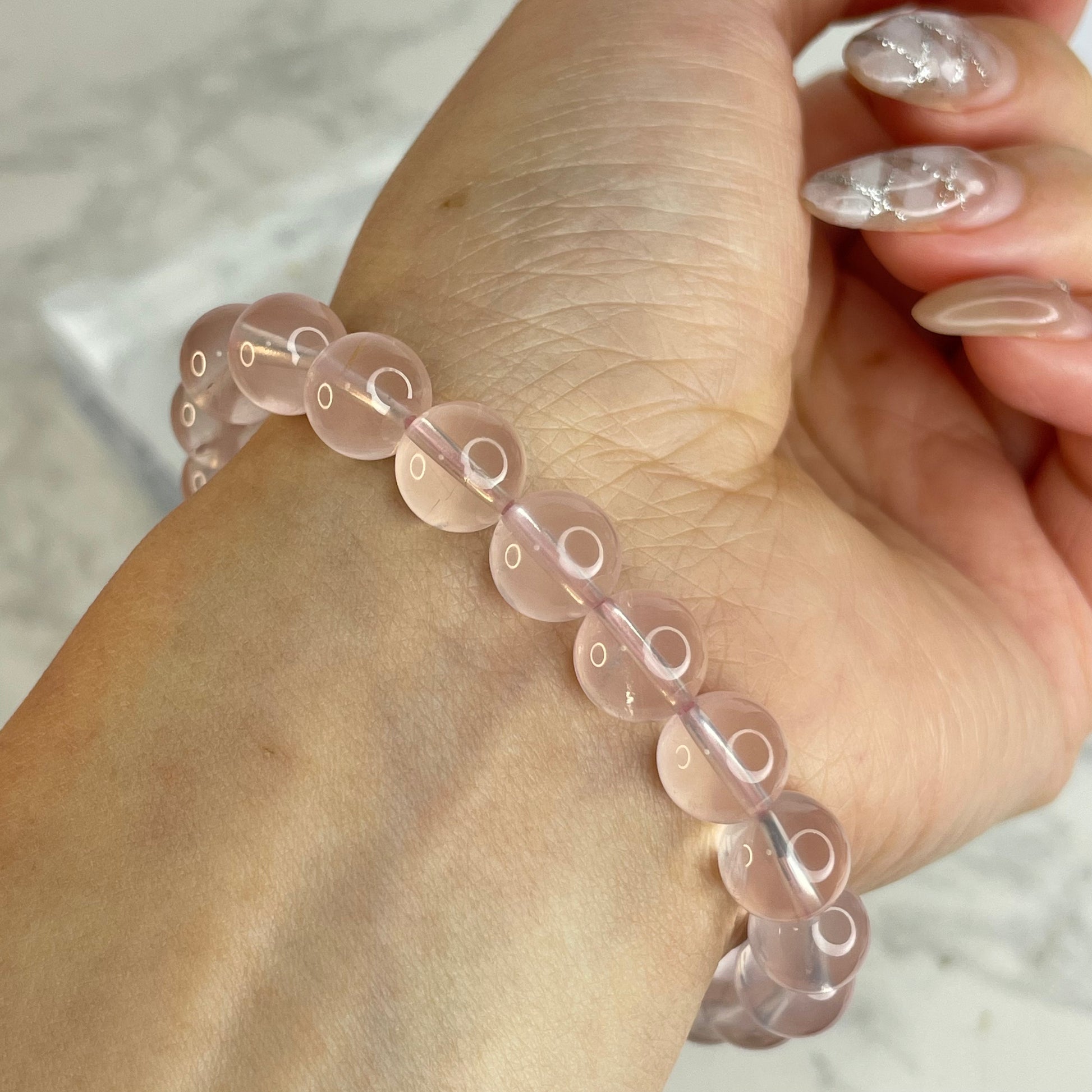 Side view of 8mm Rose Quartz bracelet on wrist, with elegant feminine look