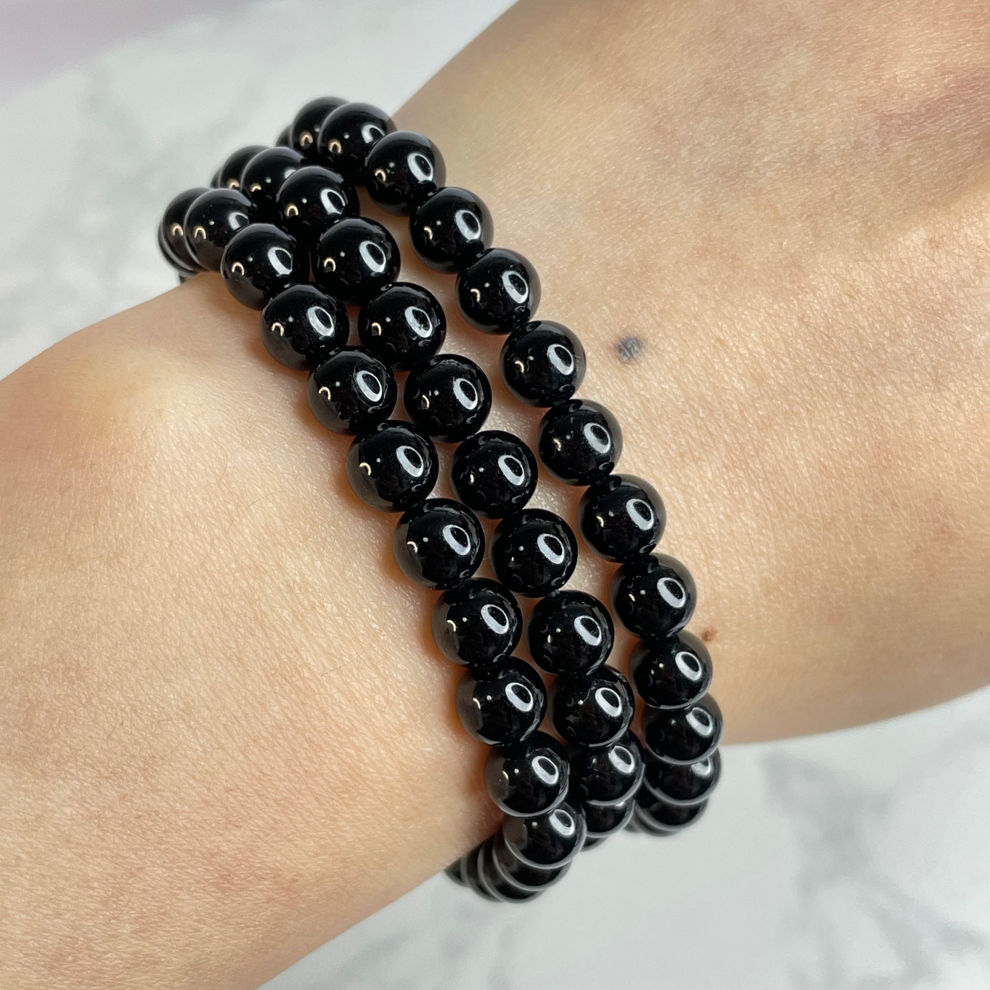 On-wrist view—Black Tourmaline bracelet worn in three wraps; neat spacing and even bead luster.
