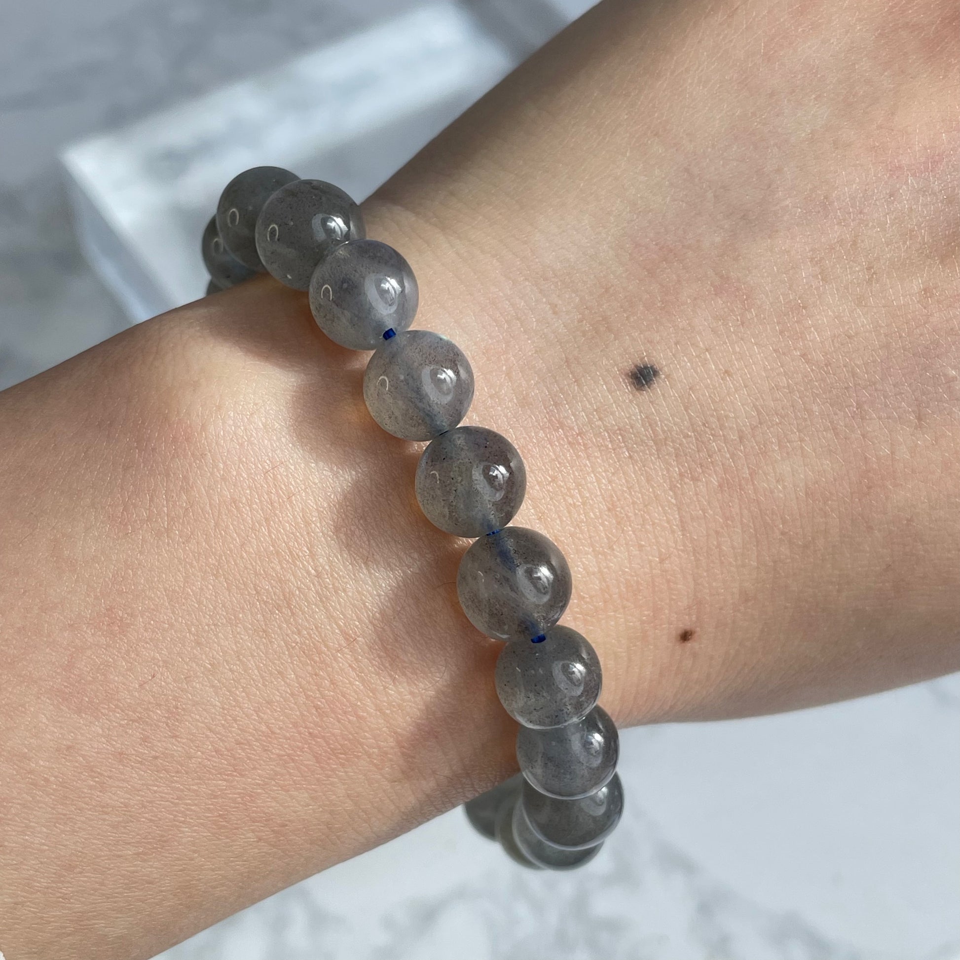 Labradorite bracelet worn on wrist, showing subtle blue sheen on grey beads.