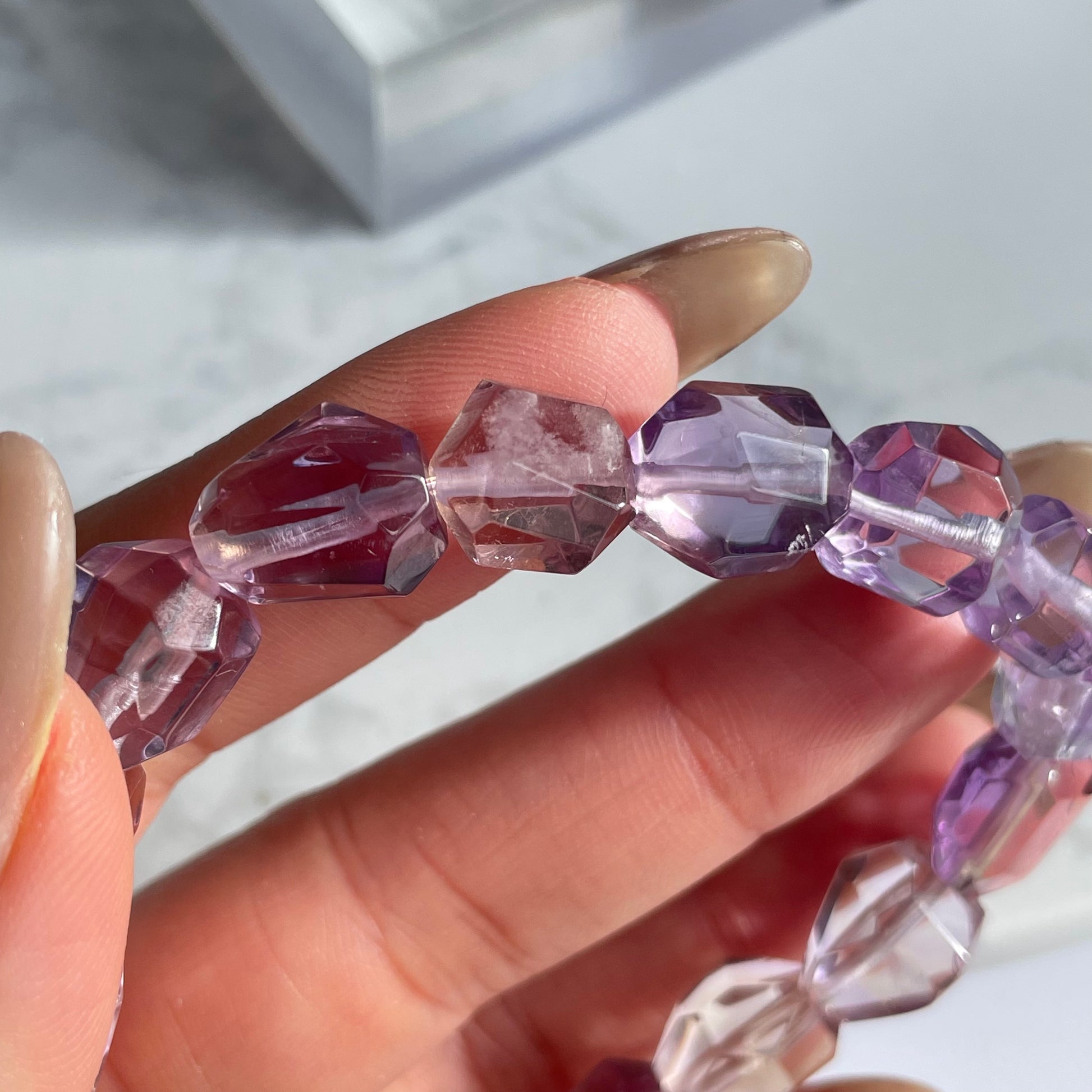 Detailed view of raw-cut ametrine bracelet, highlighting the faceted bead with internal cloudy inclusion and vivid purple-gold tones.