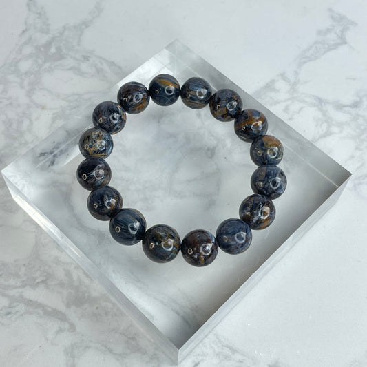 Power Core 13mm Pietersite crystal bracelet – dark swirling beads from Namibia with golden and blue chatoyancy, enhancing strength and inner clarity.
