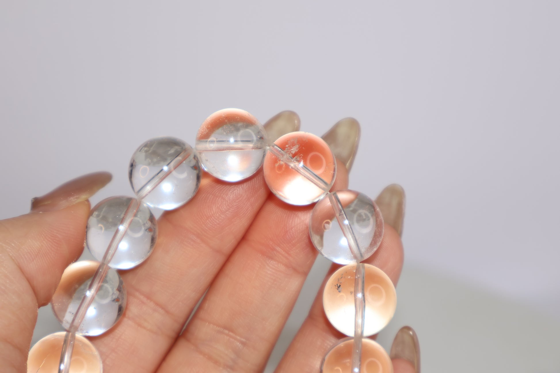 Close-up of Mystic Clarity Clear Quartz bracelet bead with visible phantom inclusion, showcasing natural mineral formation within 14mm crystal.