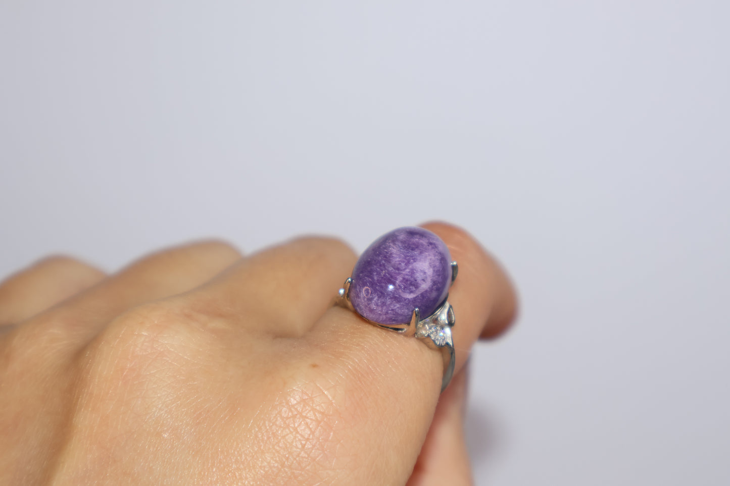 Adjustable purple charoite cabochon ring close-up on model hand