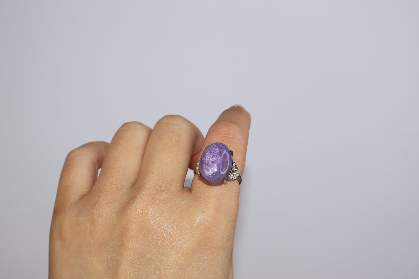 Adjustable purple charoite cabochon ring close-up on model hand