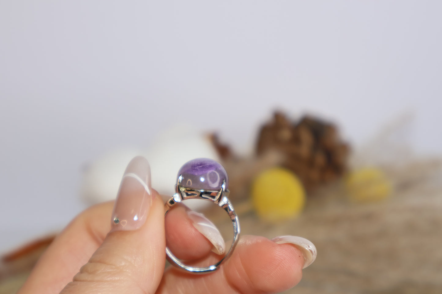 Natural lighting shot of purple charoite crystal ring being held for detail view