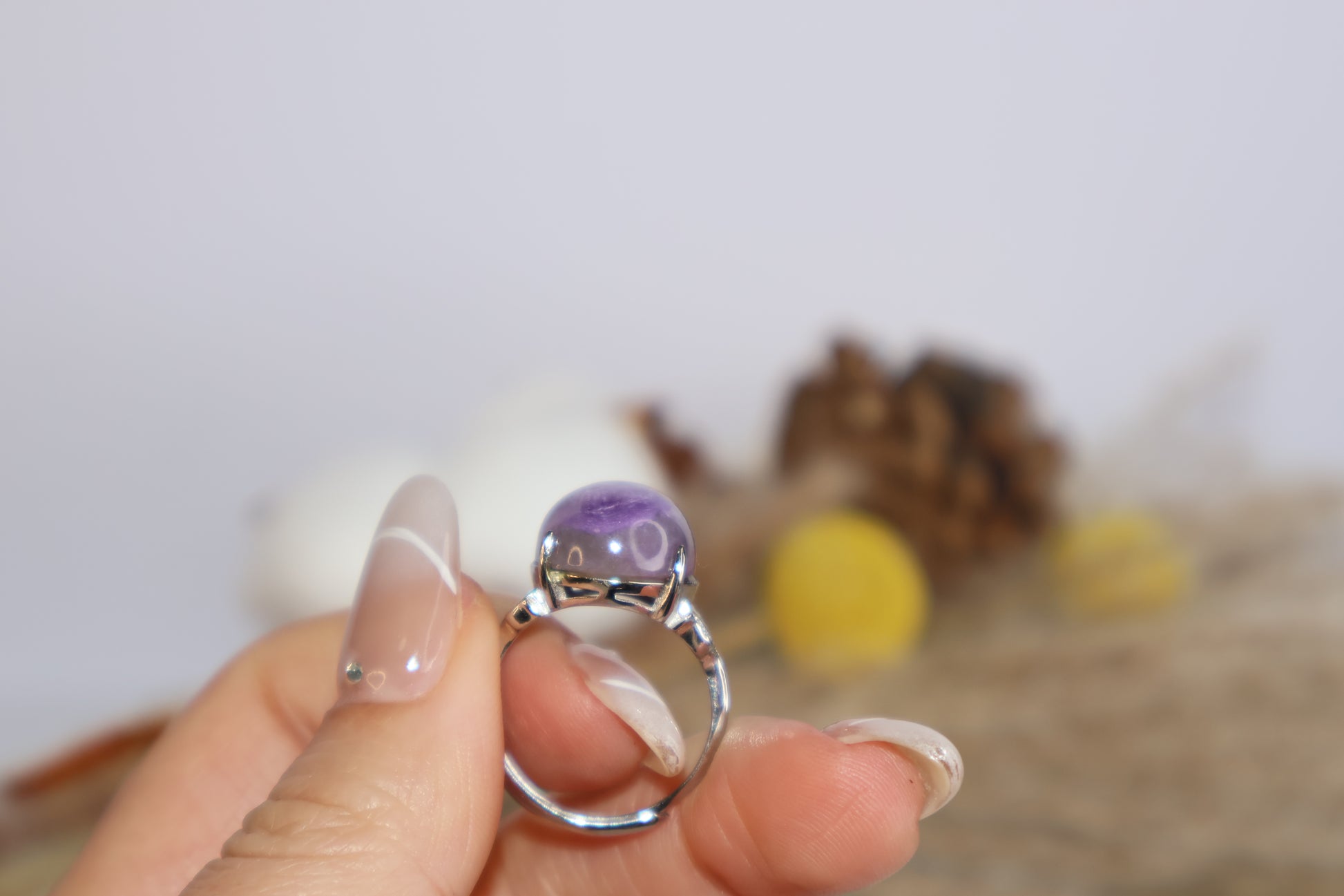 Natural lighting shot of purple charoite crystal ring being held for detail view