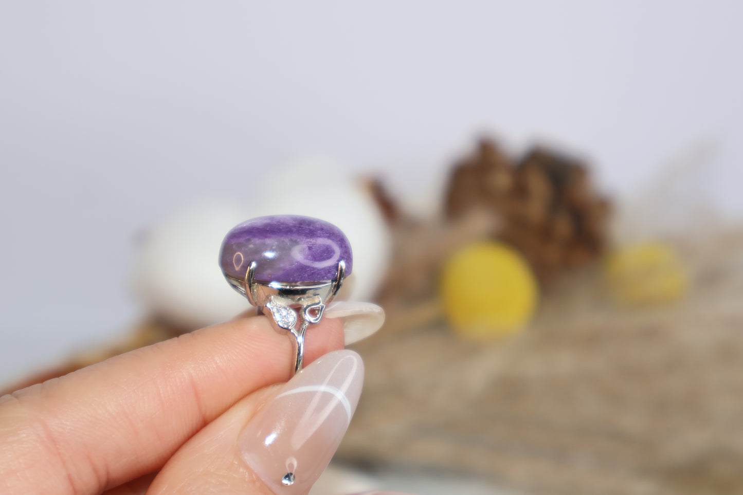 Natural lighting shot of purple charoite crystal ring being held for detail view