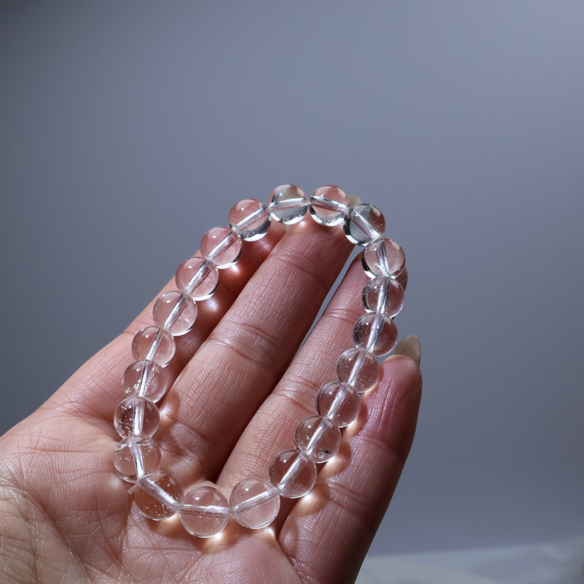 Palm view of 9mm clear quartz bracelet – natural crystal energy accessory