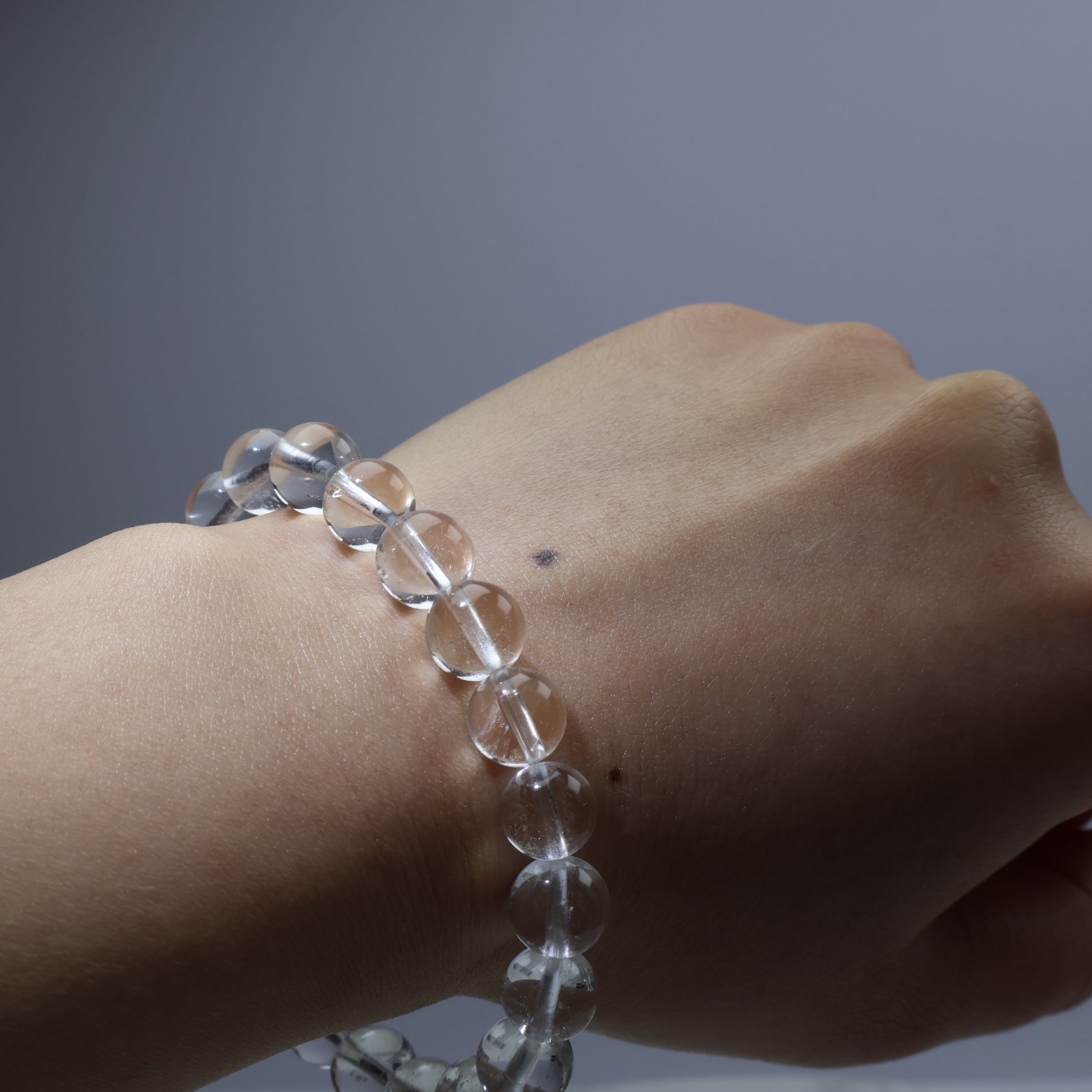 Close-up of semi-clear white quartz on palm – 9mm beads