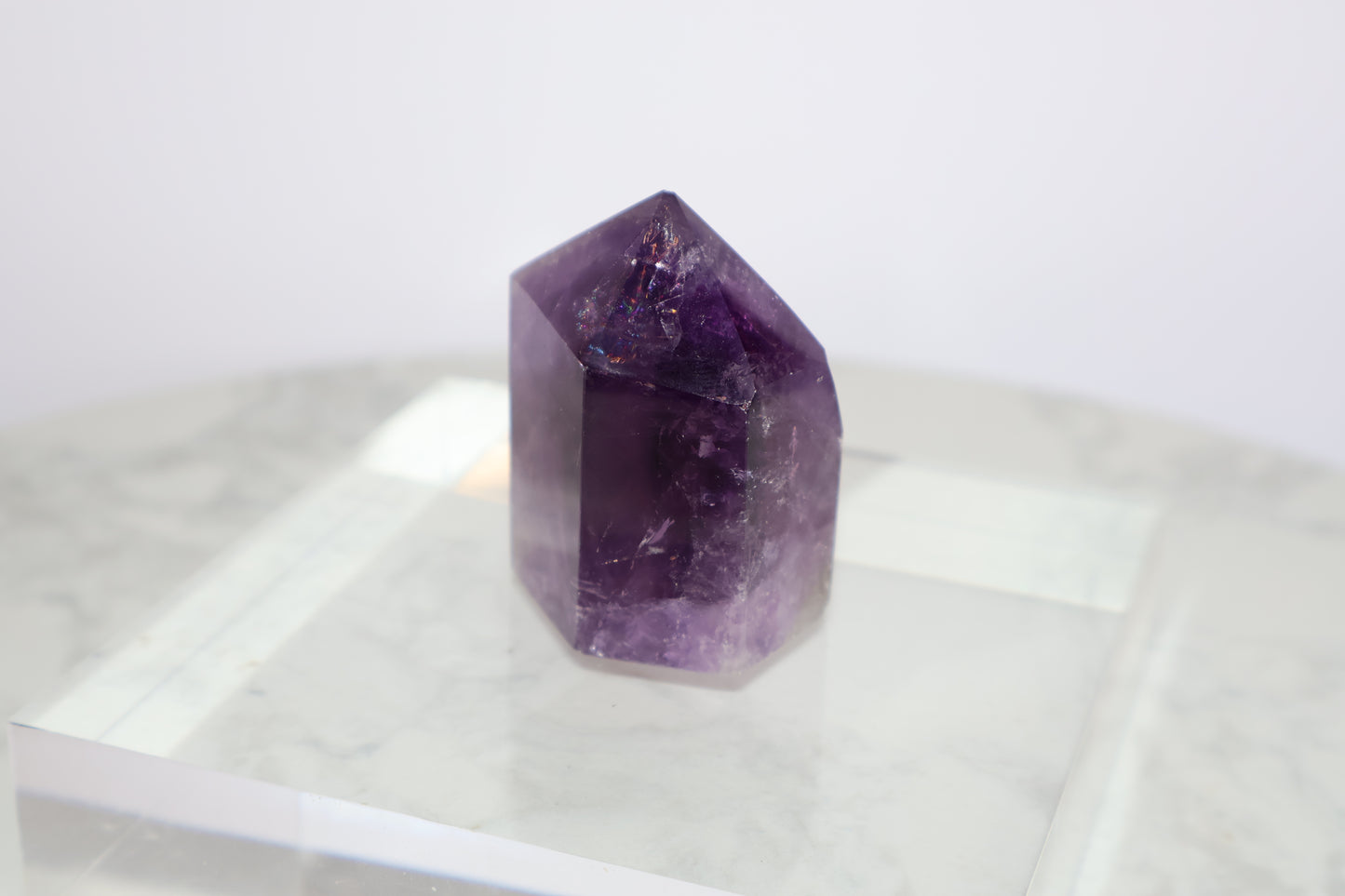 Side angled view of Royal Amethyst Tower No.01 – 98g with visible rainbow flashes and deep purple clarity