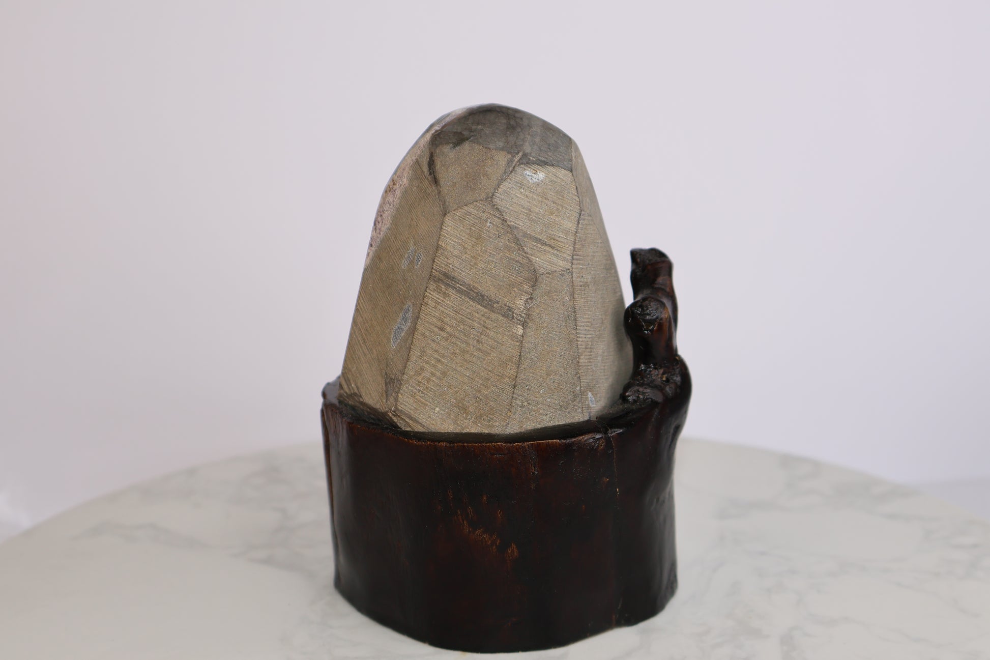 Back view of natural amethyst geode showing raw stone texture and dark wooden base
