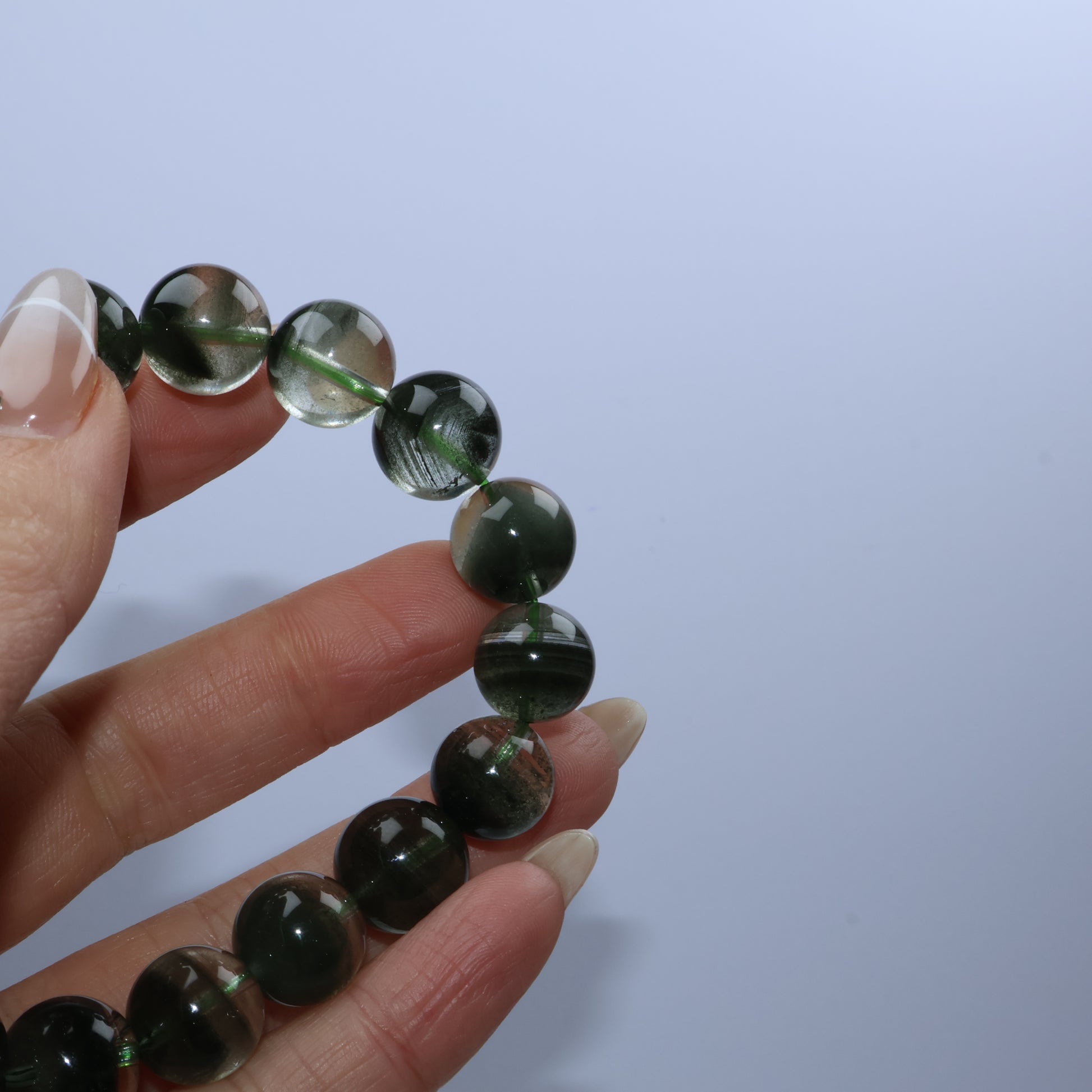 Close-up of fingers holding several beads showing phantom textures inside