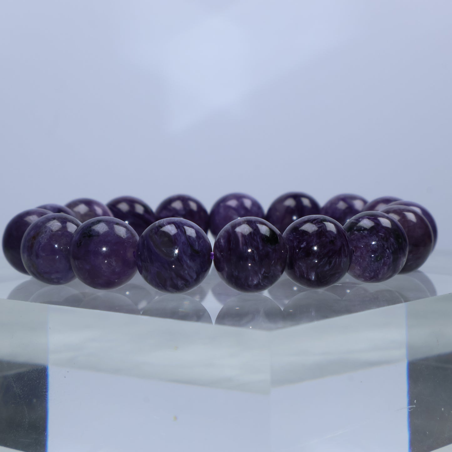 Close-up of richly saturated Charoite beads with fibrous swirls