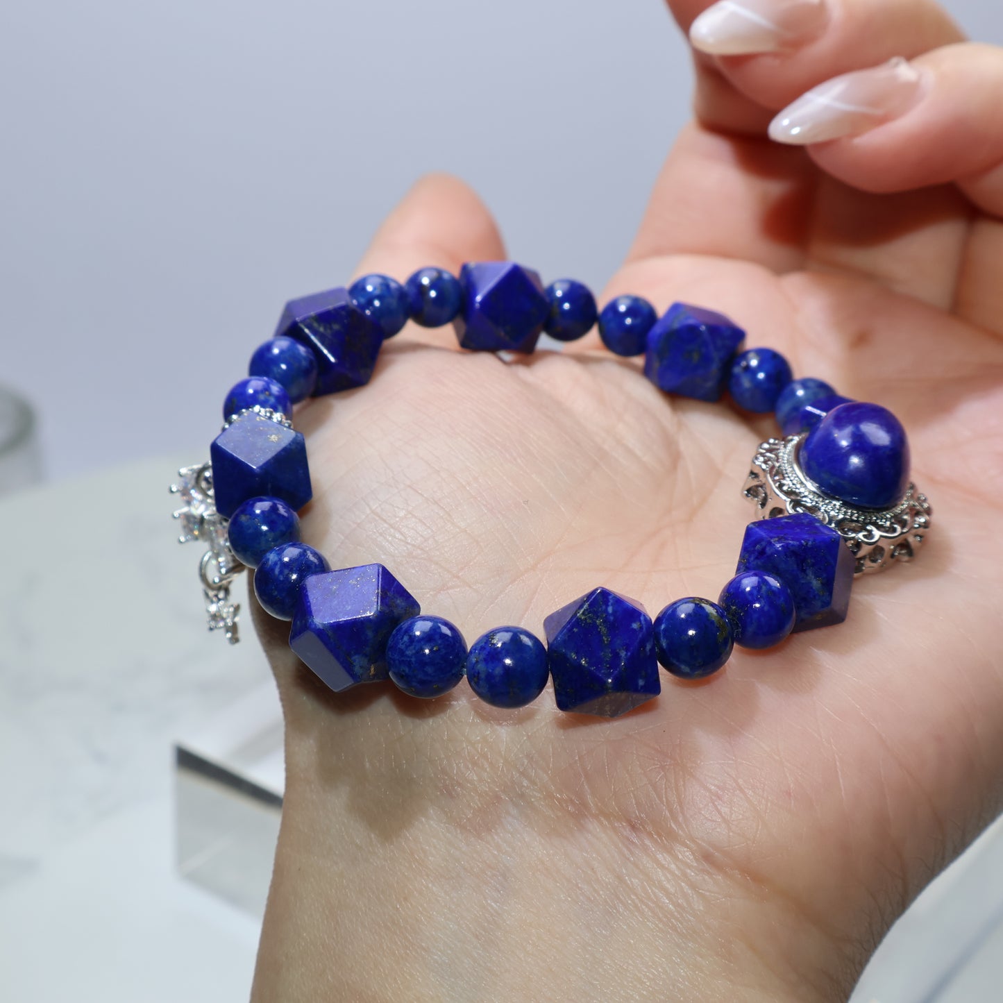 Full view of Lapis Lazuli bracelet on open palm with round and faceted bead details