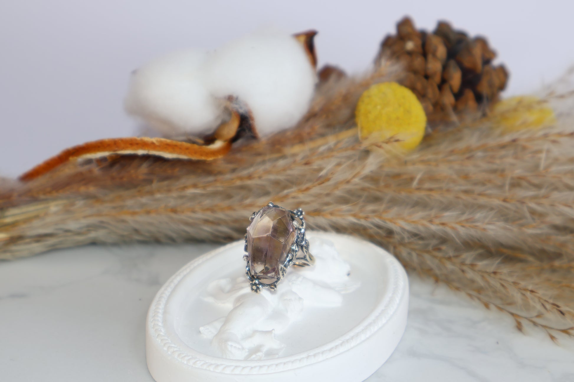 Close-up of oval Ametrine crystal ring on white display